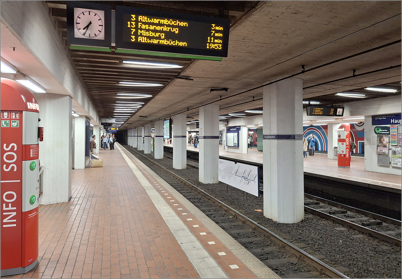 Die erste U-Bahnstrecke in Hannover  - 

... wurde am 26.09.1975 vom Hauptbahnhof bis zur Rampe an der Gustav-Bratke-Allee mit vier U-Bahnh�fen in Betrieb genommen.

Im Gegensatz zu Stuttgart und K�ln wurden die Tunnels von Beginn an in U-Bahnstandard erstellt, was die Trassenf�hrung angeht als auch die Ausr�stung mit Hochbahnsteigen von Beginn an. Zu dieser Zeit der Betrieb mit stra�enbahn�hnlichen Fahrzeugen nur als Zwischenzustand angesehen bis nach entsprechenden Verl�ngerungen der Strecken eine Umstellung auf U-Bahnbetrieb erfolgen sollte, vergleichbar dem Pre-Metrobetrieb in Br�ssel und Antwerpen. In Br�ssel erfolgte bei zwei Strecken die Umstellung auf echten U-Bahnbetrieb.

Die ersten U-Strab-Anlagen in K�ln und Stuttgart haben hingegen engere Kurvenradien und im Falle von K�ln auch niveaugleiche Abzweige. 

Letztlich wurden die Tunnelanlagen nach dem Bau der Innenstadtstrecken in Hannover nicht weiter verl�ngert und es wird dauerhaft bei einem Stadtbahnbetrieb bleiben.

Hier ein Blick in die viergleisige U-Bahnstation Hauptbahn mit den Gleisen der A-Strecke in der Mitte. 1979 ging hier auch die B-Strecke auf den beiden Au�engleisen in Betrieb und so ist hier ein vorbildlicher Umstieg zwischen den Linien der A-  und denen der B-Strecke m�glich.

05.05.2026 (M)