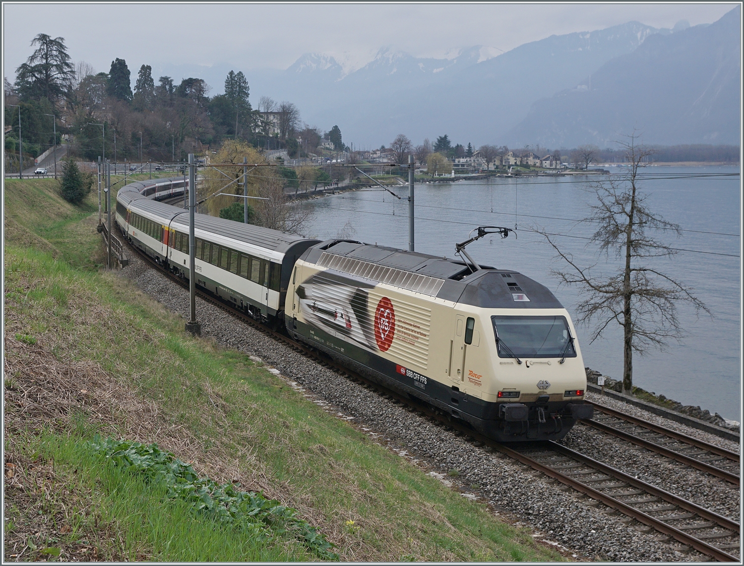 Die für „175 Jahre Schweizer Bahnen“ werbende SBB 460 019 schiebt den IR 90 1815 bei Villeneuve in Richtung Brig. 

28. Februar 2024