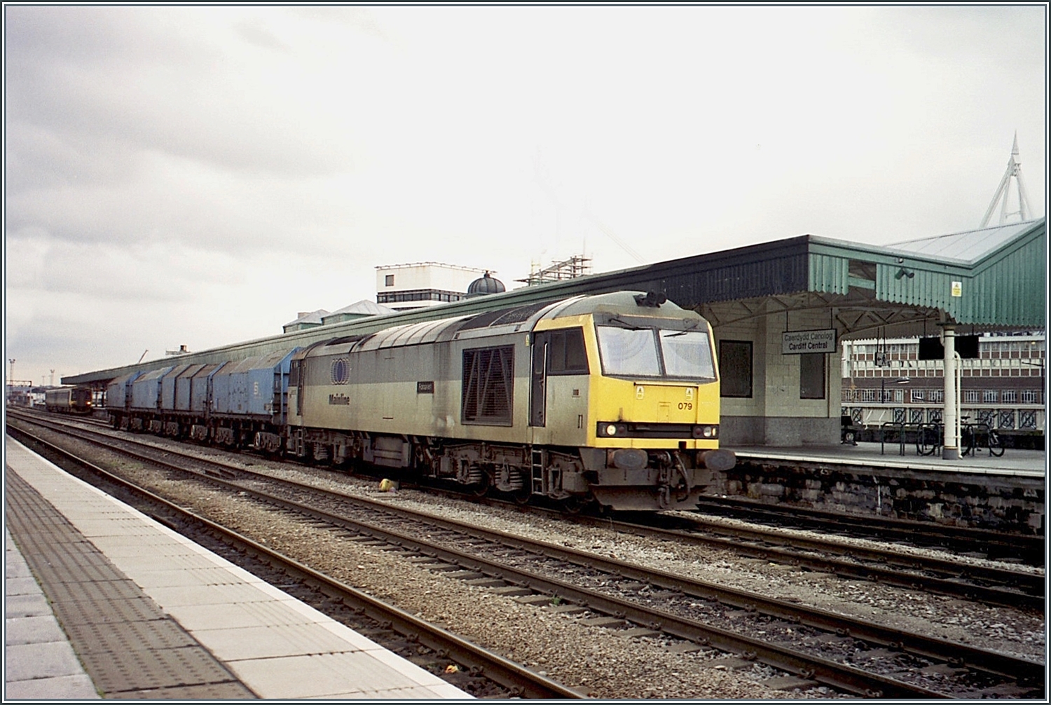 Die  Mainline  Class 60 079 fährt mit einem Telehauben- Güterzug durch den Bahnhof von Cardiff Central /Caerdydd Canolog. 

Analogbild vom November 2000 