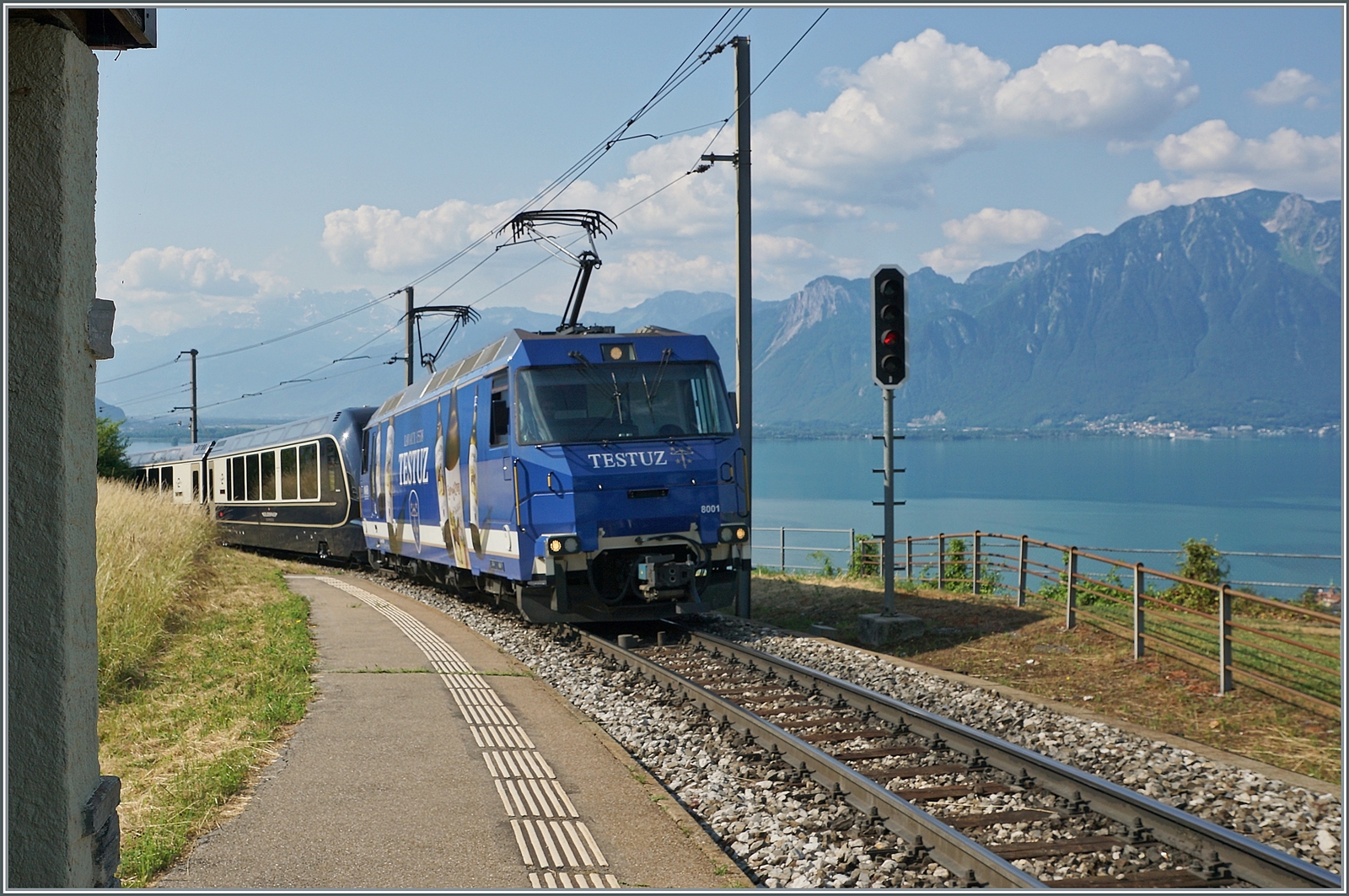 Die MOB Ge 4/4 8001 ist mit ihrem GPX 4068 auf dem Weg von Montreux nach Zweisimmen, wobei der Zug selbst allem Anschein nach wieder bis Interlaken Ost weiterfahren wird, d.h. die nicht entdeckten Probleme infolge ungenügender Probefahrten im mehr als langen Vorfeld vor der Inbetriebnahme wohl eine Lösung gefunden haben. 
Das Bild entstand im Schatten des kleinen Wartehäuschen der Station Châtelard VD, welches mir leider etwas Probleme mit der Fokussierung bereitete, welche sich in einer nicht ganz einwandfreien Schärfe des Zuges äussert.

16. Juni 2023

