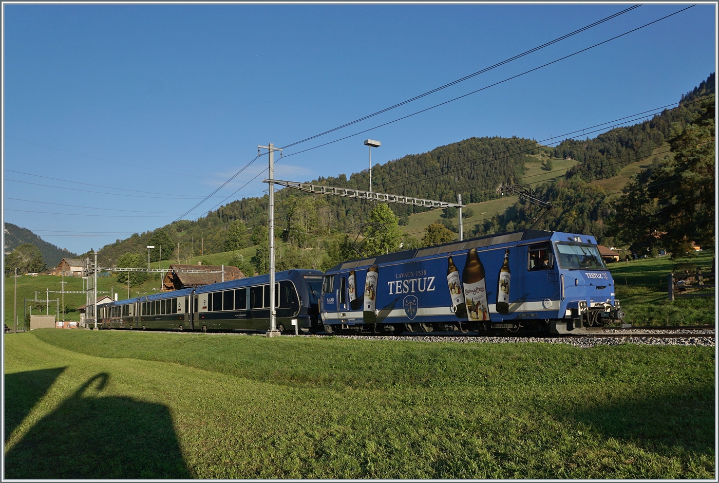 Die MOB Ge 4/4 8001 fährt im frühen Morgenlicht mit dem ersten GoldenPass Express des Tages durch Rossinière in Richtung Zweisimmen. Der GPX 4064 ist von Montreux nach Interlaken Ost unterwegs. 

29. Sept. 2023