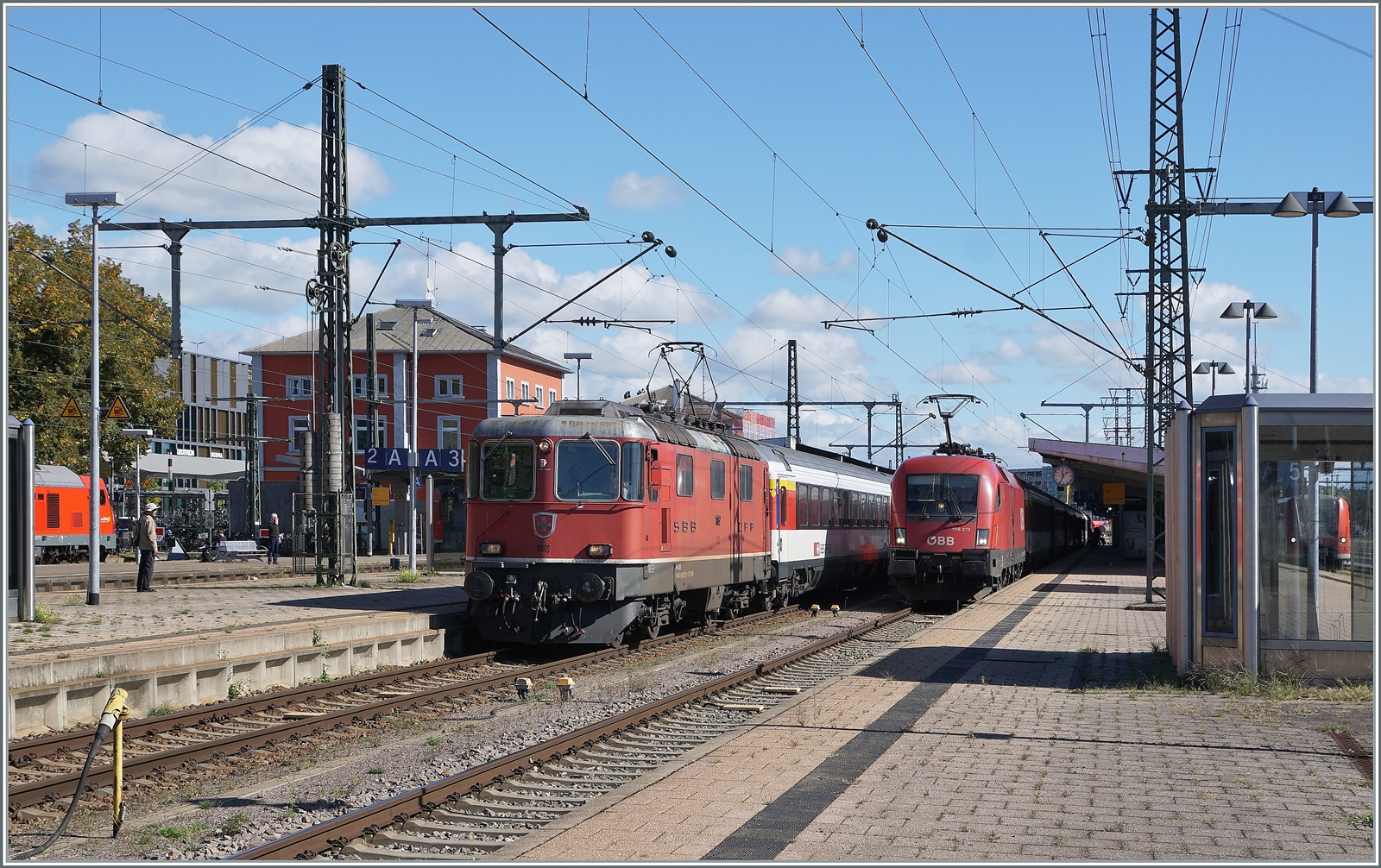 Die SBB Re 4/4 II 11152 mit ihrem IC nach Zürich und die ÖBB 1116 273 mit ihrem IC nach Stuttgart warten in Singen auf die Abfahrt.

19. September 2022