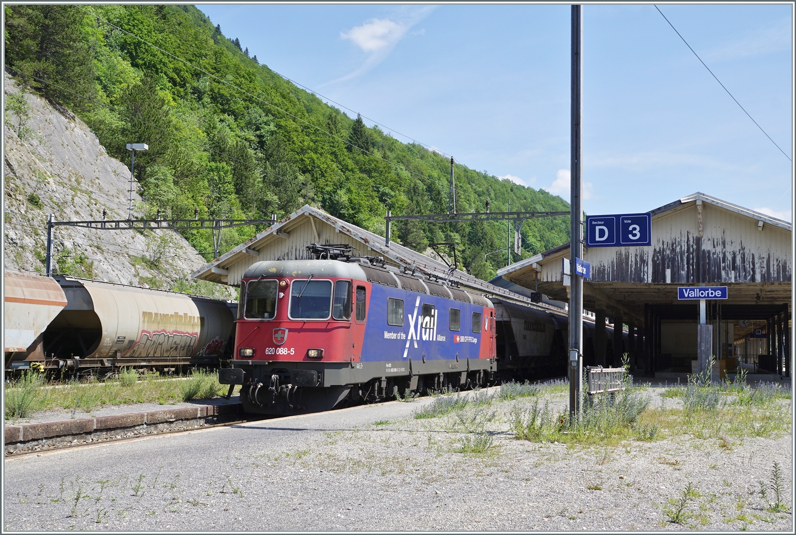 Die SBB Re 6/6 11688 (Re 620 088-5)  Linthal  in der Rail-X Lackierung hatte in Domo II den   Spaghetti -Zug übernommen und ist nun in Vallorbe eingetroffen, wo sie von SNCF Loks abgelöst werden wird. Links im Bild ist der Gegenzug zu erkennen. 

16. Juni 2022