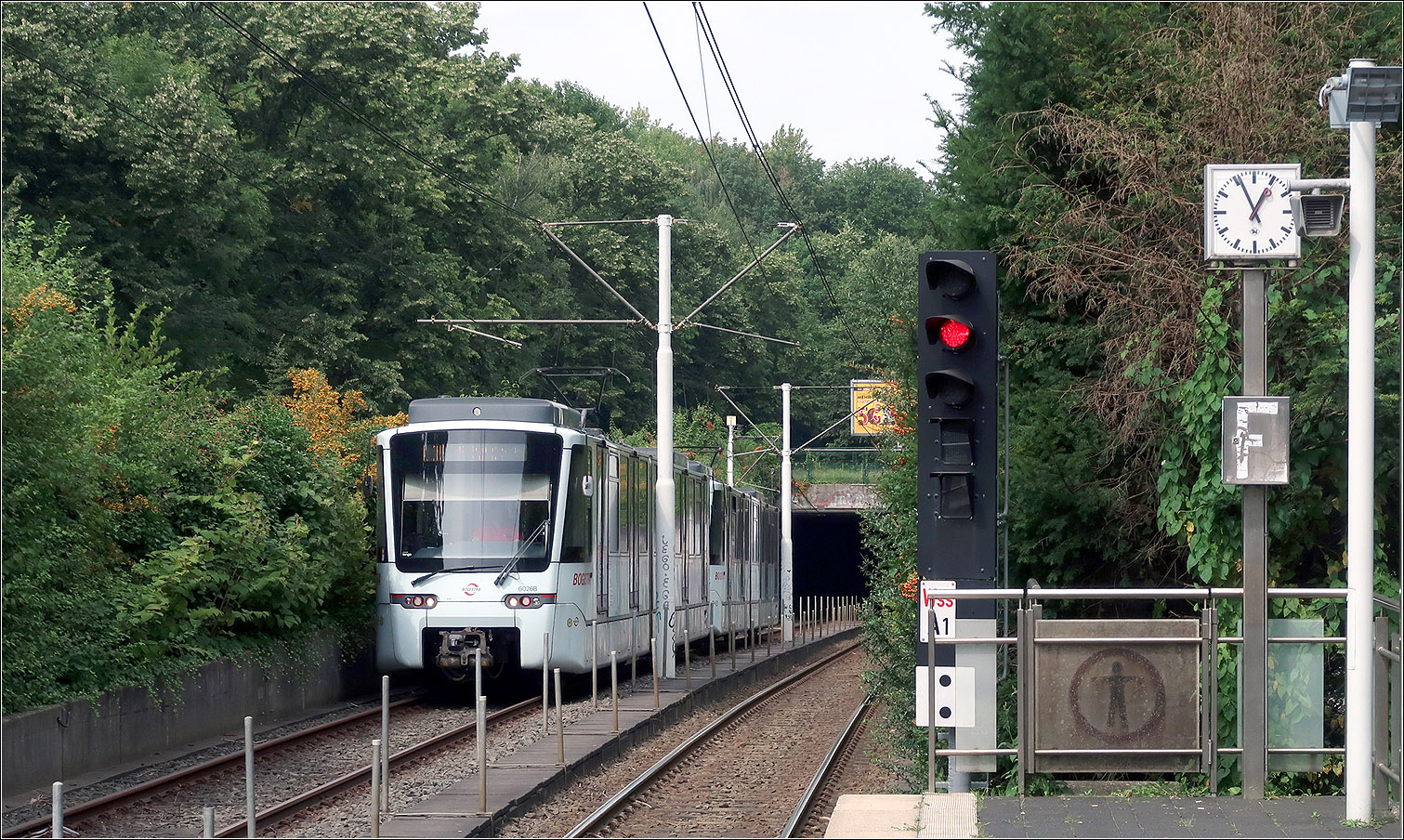 Die U35-Süd in Bochum - 

1993 wurde die U35 vom Hauptbahnhof nach Hustadt weitergeführt, wobei eine in den 1970ige Jahren gebaute Schnellstraßenbahnlinie für die Stadtbahn adaptiert wurde. Diese wurde durch eine ab dem Hauptbahnhof um zwei Stationen verlängerte Tunnelstrecke an die U35 angeschlossen.

Da es auf der ansonsten kreuzungsfreien oberirdischen Strecke drei Bahnübergänge gibt, hat mit dieser Verlängerung die U35 auch ihren Status als 'echte' U-Bahn verloren.

Im Bild befährt ein Stadler Tango-Stadtbahnzug die Tunnelrampe an der Haltestelle Wasserstraße.

22.08.2023 (M)
