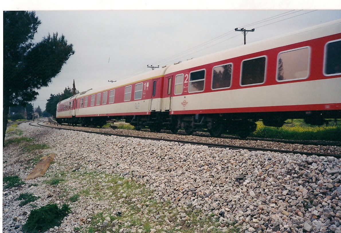 Diesel-elektrische Triebwagen der Baureihe A520 (AEG-LEW 1989) der OSE (Griechische Staatsbahn) durchfahrt den Bahnhof Acharnai in Attiki, 2002. Diese Triebwagen haben die Achsfolge Bo-Bo in vorderen bzw. hinteren Lokomotiven. Sie haben eine Höchstgeschwindigkeit von 160Km/h und OSE rief sie IC (InterCity) an.