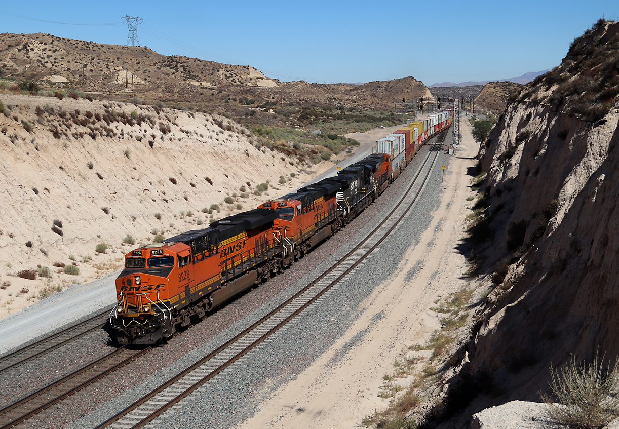 Dieser Containerzug wechselt in der Nachmittagssonne auf der Passhöhe das Gleis für die Talfahrt Richtung San Bernardino. Cajon Pass, CA, 21.9.2022