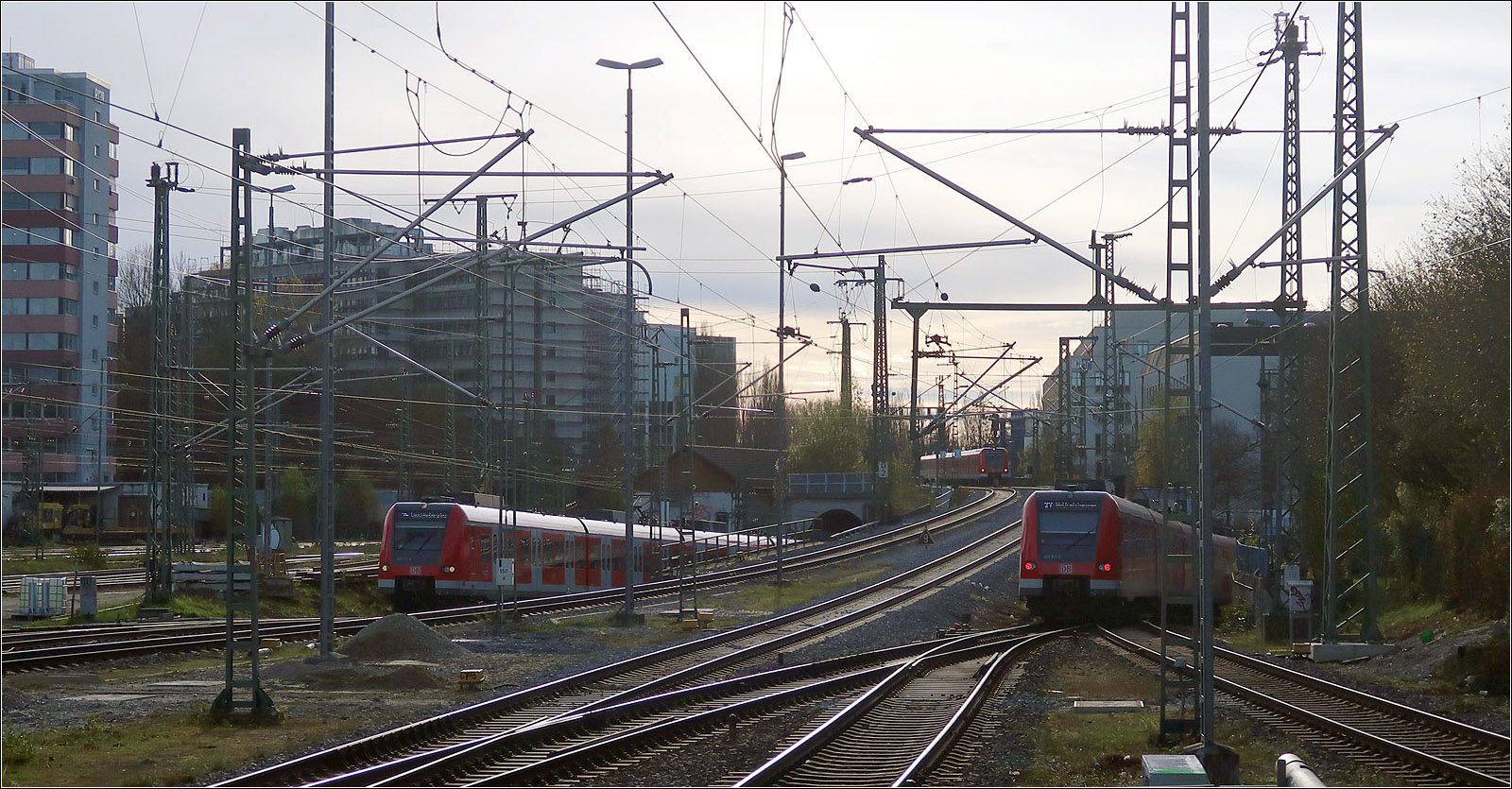 Drei auf einen Streich - 

Links erreicht ein S-Bahnzug nach der Durchfahrt des Stammstreckentunnels wieder die Oberfläche. Oben in der Mitte kommt ein Zug im Linksverkehr aus Richtung Giesing und wird nach Kopfmachen im Ostbahnhof in den Tunnel einfahren, wie auch die S-Bahn auf der rechten Seite.

München-Ostbahnhof, 07.11.2022 (M)