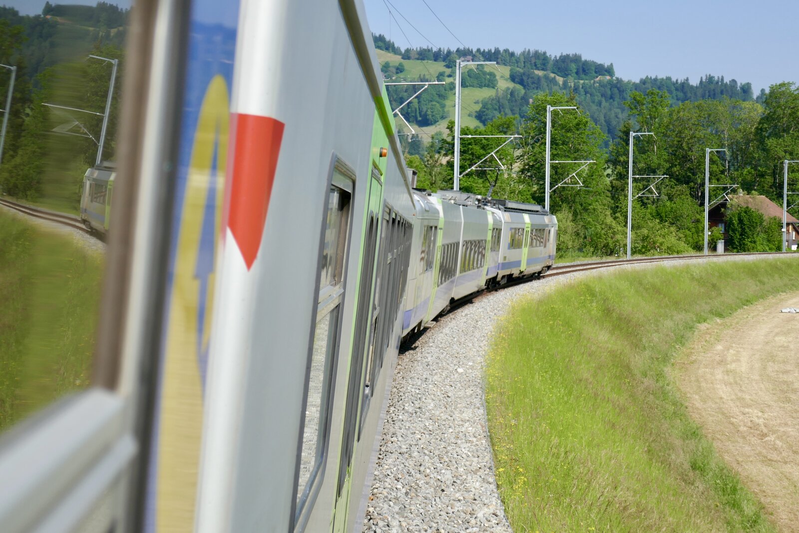 Ein Bild aus dem Fenster des ABt 963 mit dem führenden RBDe 565 723 am 6.6.23 zwischen Langnau i.E. Und Neumühle.