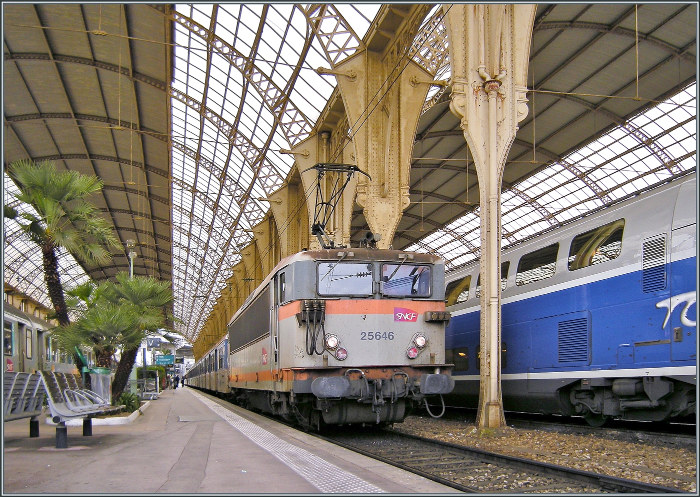 Ein Blick zur�ck: Nach etlichen Reisen nach Nice, infolge g�nstiger Verbindungen im Liegewagen (Gen�ve - Nice) in jungen Jahren auch mal f�r nur einen Tag am Strand, waren wir 2009 zum letzten mal in Nice,  damals waren die TGV Z�ge noch blau/silbern gestrichen und im Regionalverkehr waren oft noch die SNCF BB 25500 mit Rio Garnituren im Einsatz, welche unklimatisiert  in der W�rme am Mittelmeer einen ganz besonderen Reiseeindruck hinterliessen...
In Nice Ville steht die BB mit einem Regionalzug in Richtung Cannes in der herrlichen, palmengeschm�cken Halle von Nice-Ville. 

21. April 2009