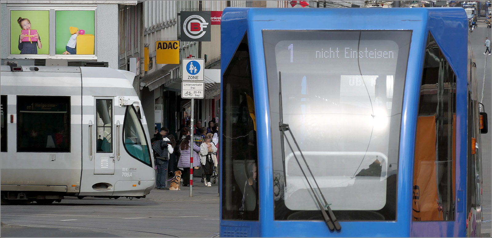 Ein etwas gewagtes Bild - 

.. mit einer an der Haltestelle Rathaus abbiegenden RegioTram und einem Straßenbahnzug mit Beiwagen auf der Linie 1, die hier geradeaus die Kreuzung quert. 

20.03.2024 (M)


