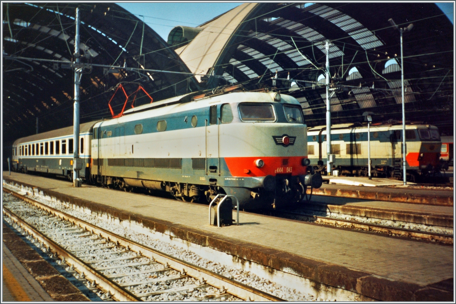 Ein formschöner FS Klassiker: die E 444 046  Tartaruga  (Schildkröte) mit einem Intercity vor den imposanten Halle des Bahnhofs von Milano Centrale. 

Analogbild vom Marz 1993