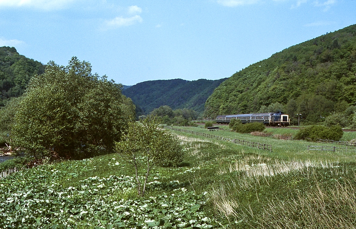 Eine 212 ist zwischen Hoenningen und Dmpelfeld mit einem Nahverkehrszug nach Adenau unterwegs. Die Aufnahme entstand im Mai 1985, wenige Wochen vor der Gesamtstillegung der Strecke zwischen Hnningen und Adenau.