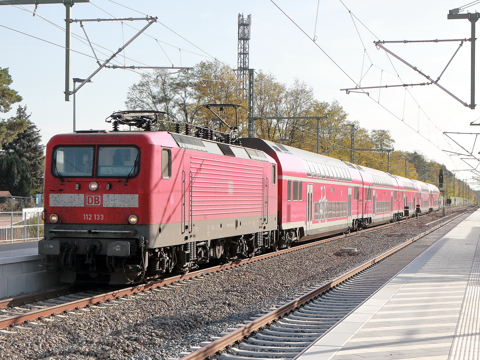 Einfahrt 112 133 als RE 5 nach Rostock in den neuen Bahnsteigbereiches im Bahhnhof Wünstdorf-Waldstadt am 28. Oktober 2022.