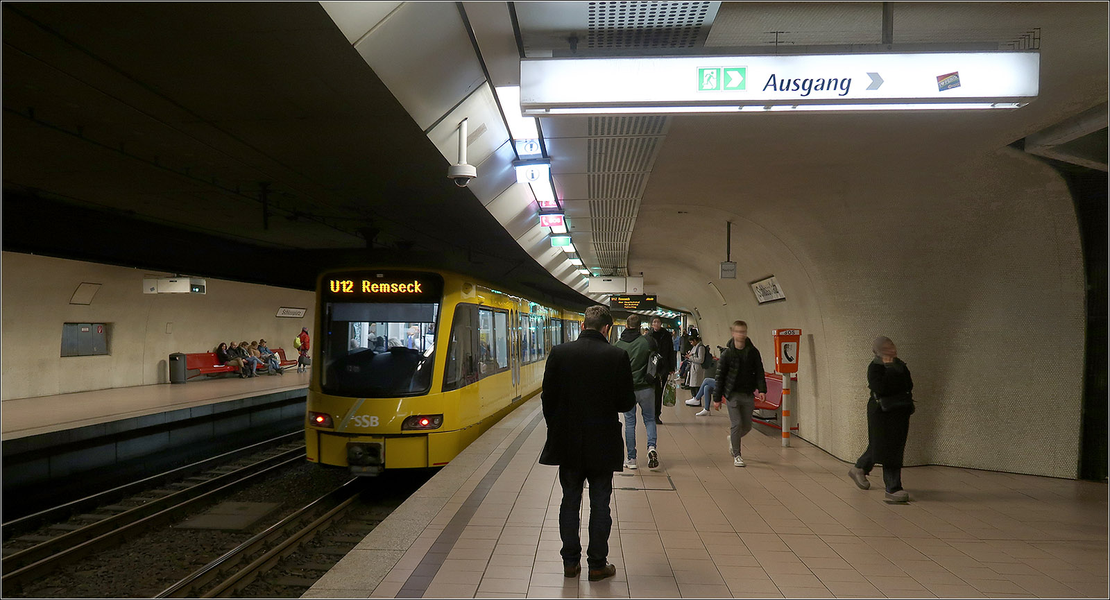 Einst ein Umsteigeknoten -

... im Stuttgarter Straßenbahnnetz war der Schlossplatz. Heute gibt es da nur noch eine Durchgangshaltestelle aber für immerhin fünf Stadtbahnlinien. 109 Haltestellen können von hier aus direkt erreicht werden, darunter auch welche in den Nachbarkommunen Gerlingen, Leinfelden-Echterdingen, Ostfildern und Remseck. Alle weiteren Ziele im SNPV in der Region sind mit einmaligem Umsteigen zu erreichen. Wichtige Umsteigeknoten in der Innenstadt sind dabei der Hauptbahnhof (Arnulf-Klett-Platz) und der Charlottenplatz.

Die Station wurde 1978 eingeweiht und wurde von Behnisch und Partner, den Architekten der Münchener Olympiadaches, gestaltet. Durch die abgerundete Formen soll dabei der unterirdische Charakter hervorgehoben werden. Im Laufe der Jahre wurde die Haltestelle auch verändert. So wurden für die Hochbahnsteige für den Stadtbahnbetrieb verlängert (ursprünglich wurde ein Teil der Hochbahnsteige mit errichtet, damals noch für eine geplante U-Bahn.) Aufzüge wurden nachgerüstet und vermutlich werden bald auch die Treppenaufgänge aus Brandschutz-Gründen durch Glaswände vom Bahnsteigbereich abgetrennt.

09.04.2024 (M)