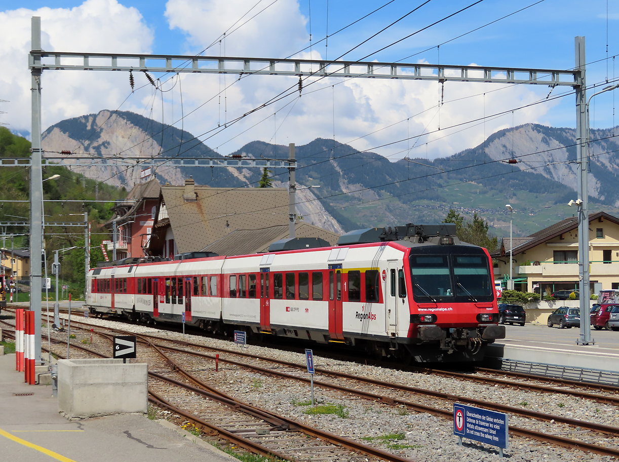 Farbenprächtiges Bild: Regionalzug der RegionAlps wartet in Orsières auf die Abfahrt nach Sembrancher. Orsières, 2.5.2022