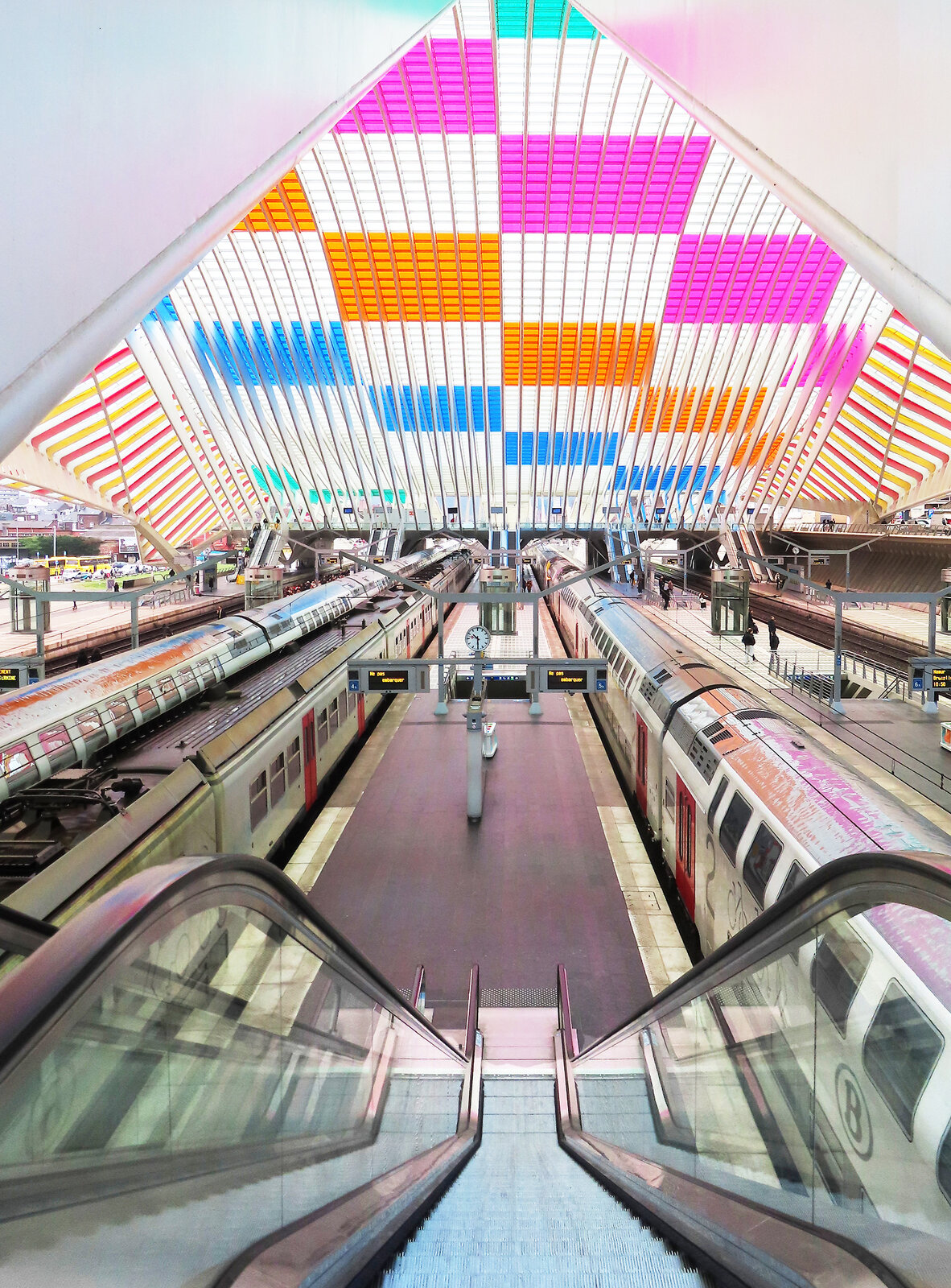 Farbige Symmetrie im Bahnhof Liège-Guillemins von der Fussgängerüberführung aus gesehen. Liège-Guillemins, 9.3.2023