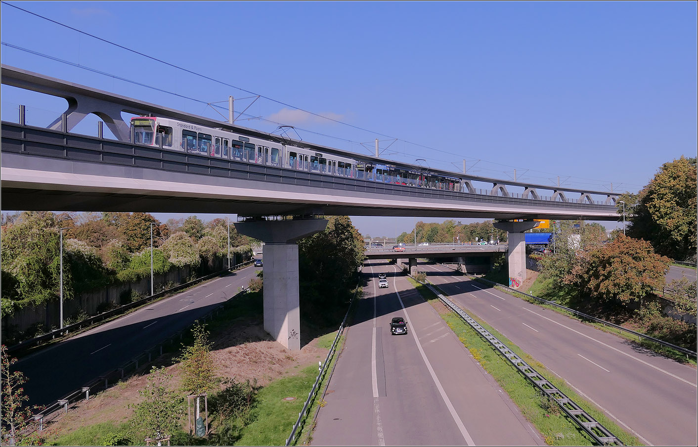 Fast unauff�llig - 

... f�gt sich der Stadtbahnzug der D�sseldorfer Linie U80 zum Flughafen in die Konstruktion der Nordsternbr�cke �ber die Danziger Stra�e (B) ein. 

Die gro�z�gige Radius der 441 Meter langenBr�cke bleibt gleich, da die Br�cke im Takt-Schiebe-Verfahren erstellt wurde.

12.10.2026 (M)