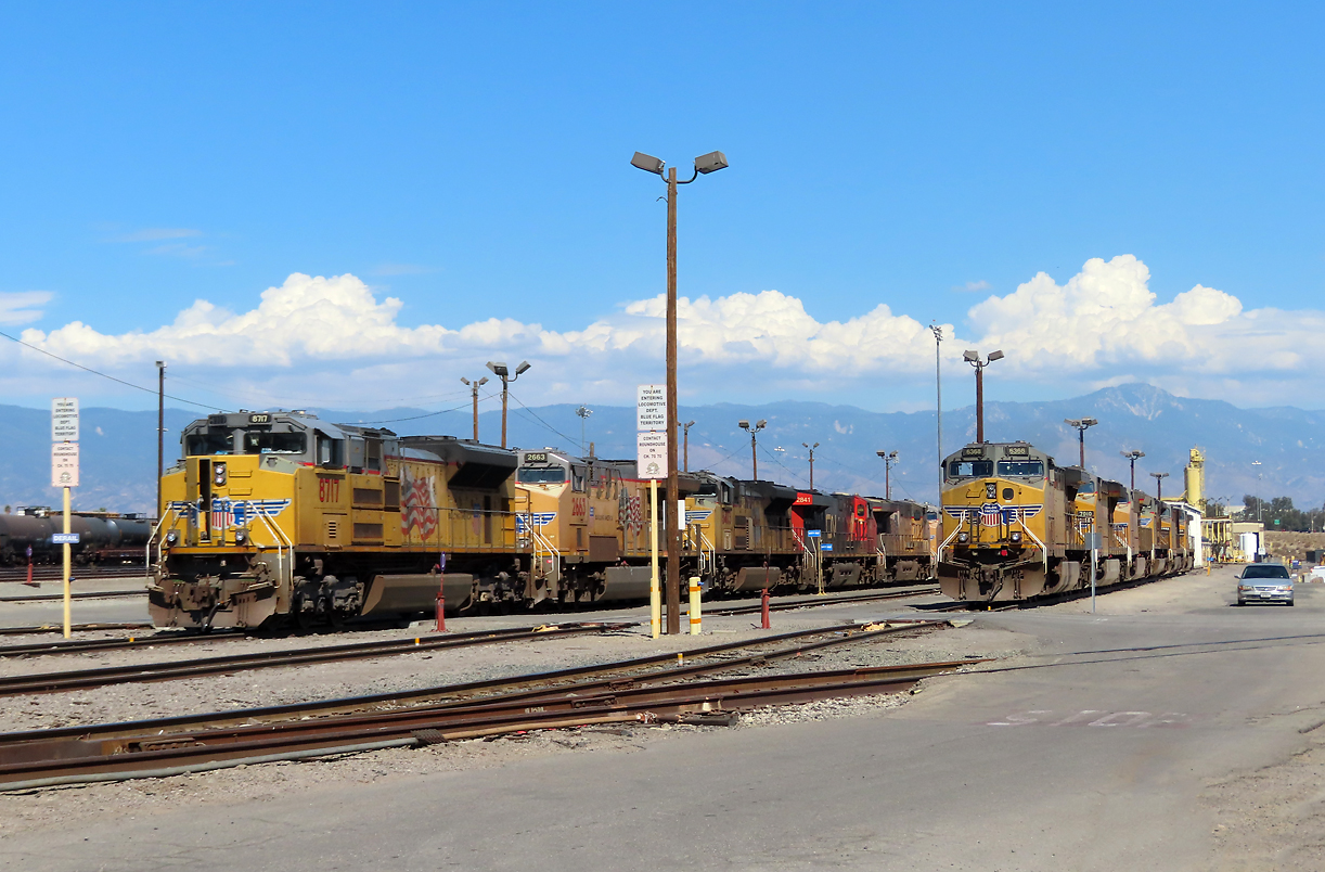 Foto von der Zufahrtsstrasse aus auf einen Teil eines Yards (Güterbahnhofs) in San Bernardino. Die rot-schwarze Lok von der CN (Canadian National) ist etwas gar weit von ihrer Heimat weg. San Bernardino, CA, 23.9.2022