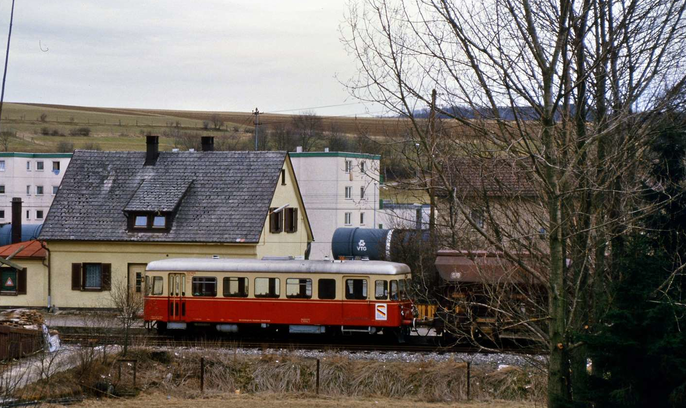 Fuchs-Schienenbus der WEG-Nebenbahn Amstetten-Gerstetten am WEG-Bahnhof Amstetten Lokalbahn (normalspurig). Amstetten besaß zu dieser Zeit noch drei reguläre Bahnhöfe: Amstetten Lokalbahnhof (normalspurig), Amstetten DB-Bahnhof in der Mitte (normalspurig) und Amstetten Schmalspurbahnhof (1000 mm Spurweite). Amstetten Lokalbahnhof war ein Übergabebahnhof, da seine Gleise zu den Gleisen der DB führten (und immer noch führen). Das Gebäude auf dem Foto ist übrigens nicht der Lokalbahnhof Amstetten, es ist nur ein verrottetes Wohnhaus in der Nähe des Lokalbahnhofs.
Datum: 01.04.1985
