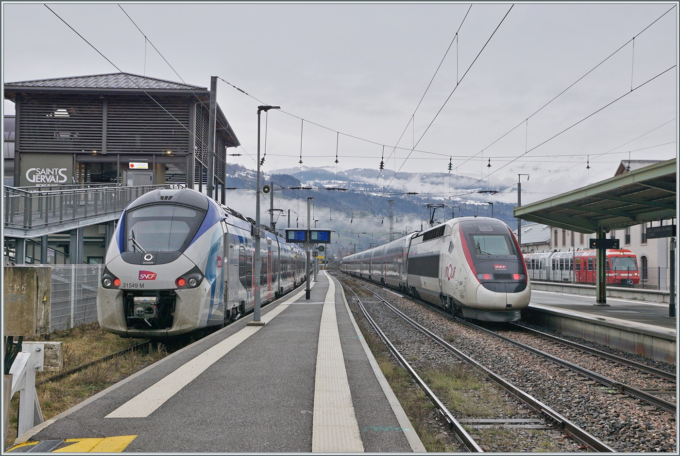 Grosskampftag bei der SNCF: An diesem Ferienwochenende wollen zahlreiche Fahrg�ste f�r ihre Wintersportferien in die Alpen reisen oder bereits wieder nach Hause fahren. Aus diesem Grund fuhr ich nach Saint-Gervais-des-Bains-Le Fayet, um mir dort den TGV Ferien-Verkehr anzusehen. Schon gleich bei der Ankunft zeigt sich der erste TGV: Der TGV Rame 864 verl�sst Saint-Gervais-les-Bains-Le Fayet (ab 10:23) als TGV 794 nach Nantes (an 19:27). Auf seiner langen Fahrt h�lt der TGV in Sallanches-Combloux-Meg�ve (10:28/10:32) und Cluse (Haute-Savoie) 10:43/10:48 und dann erst wieder in Massy-TGV (16:20/16:26) Le Mans (17:16/17.23) und Rennes (18:06/18:12) und verkehrt mit grosser Wahrscheinlichkeit via La Roche sur Foron - Annecy. 
Links im Bild steht der SNCF Coradia Polyvalent r�gional Z 31549 und rechts, weit im Hintergrund der TMR/MC BDeh 4/8 22.
21. Februar 2026