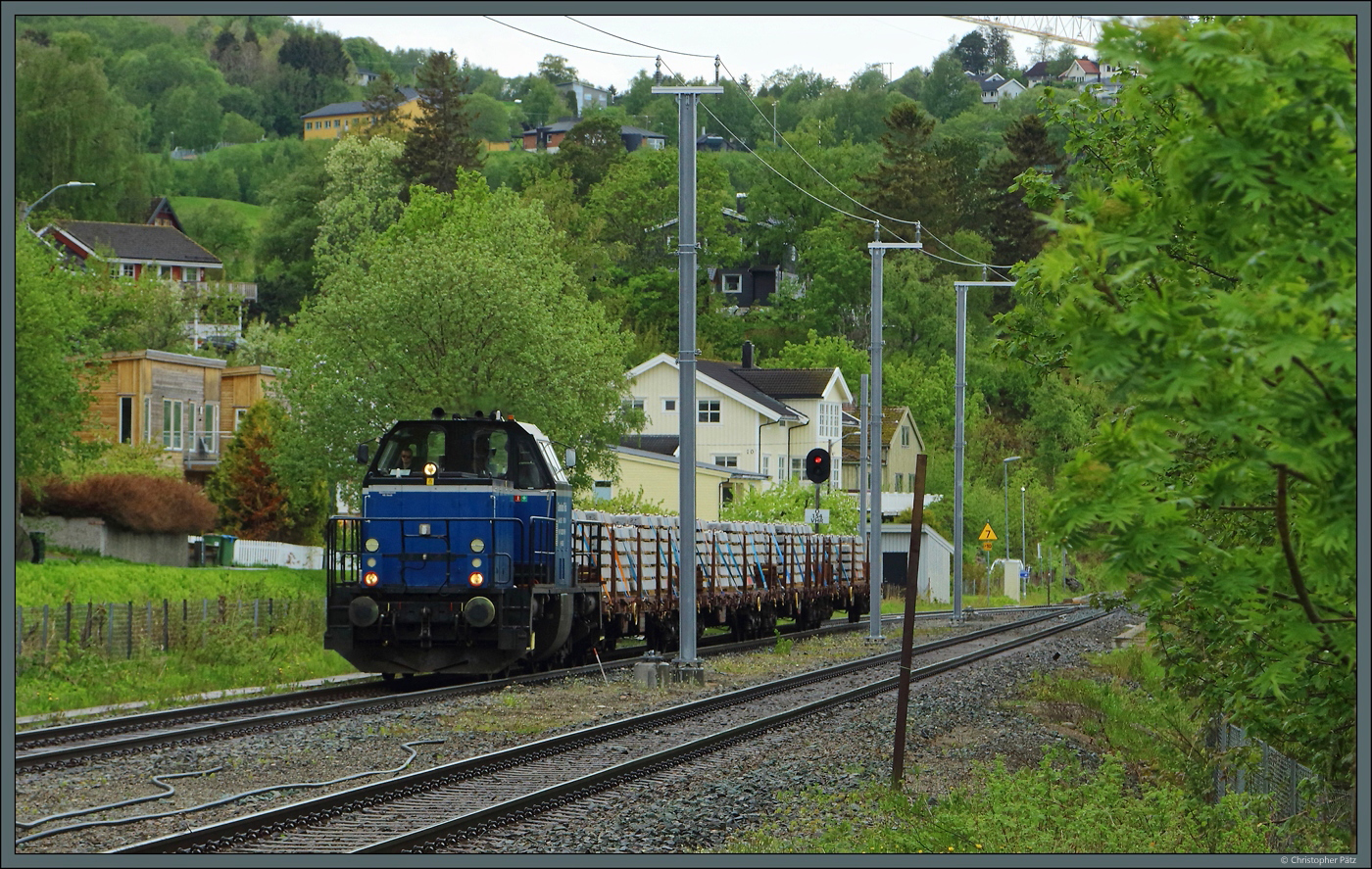 Hinter der 229 001 der Grenland Rail verbirgt sich die aus einer Bundesbahn-V100 umgebaute 214 022-6. Am 25.05.2023 rollt die Maschine mit einem Schwellenzug durch den Bahnhof Vikhammer.