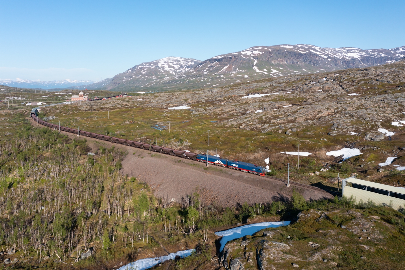 Hoch oben in Lappland fahren die größten und stärksten E-Loks in Europa. Die LKAB transportiert mit täglich rund 10 Zugpaaren das in Kiruna geförderte Eisenerz nach Narvik. Am Abend des 26.06.2022 ist der Zug 9916 kurz hinter Vassijaure auf dem Weg in Richtung Narvik.