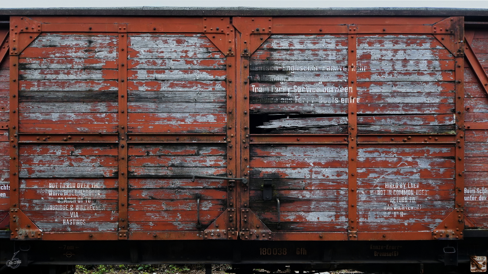 Im Bild die teilweise in englischer Sprache beschrifteten Schiebetüren eines ausgedienten Güterwagens (Gfh, 180 038), so gesehen im April 2024 auf dem Freigelände des Eisenbahnmuseums in Bochum.