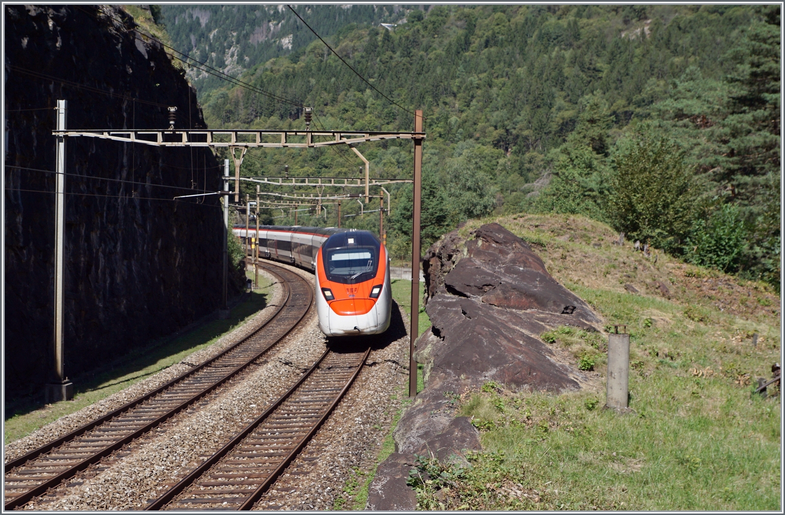 Im Juli 2016 fand ich eine Fotostelle nördlich von Faido, etwas oberhalb des Broscerinatunnel mit Blick auf die 103 Meter lange Polmengobrücke. Als ich die Fotostelle dieses Jahr erneut aufsuchte, ging ich einen Schritt weiter, genauer gesagt, bis zu einem verlassen  Wärterhaus  kurz vor dem oberen Portal des 1567 Meter langen Pratotunnel, der als 360 ° Kreiskehrtunnel gut 40 Meter Höhenunterschied überwindet. Das Bild zeigt den IC 10667 der von Basel SBB nach Lugano unterwegs ist und unmittelbar hinter meinem Rücken den Prato Kreiskehrtunnel erreiche wird. Die beiden SBB Giruno RABe 501 konnte ich gut zwei Minuten später auf der Polmengobrücke erneut fotografieren (siehe Bild ID 1347584). 
Gerade solche Erlebnisse machen den Reiz der Gotthardbahn aus.

4. September 2023 
