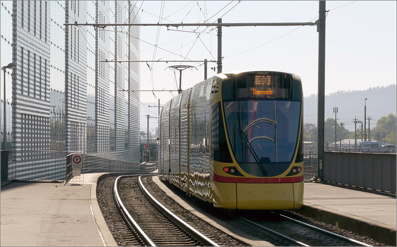 Im morgendlichen Gegenlicht - 

... setzt sich ein Stadler Tango-Tram der Linie 10 nach Dornach an der Haltestelle Peter Merian in Bewegung. 

18.09.2025 (M) 