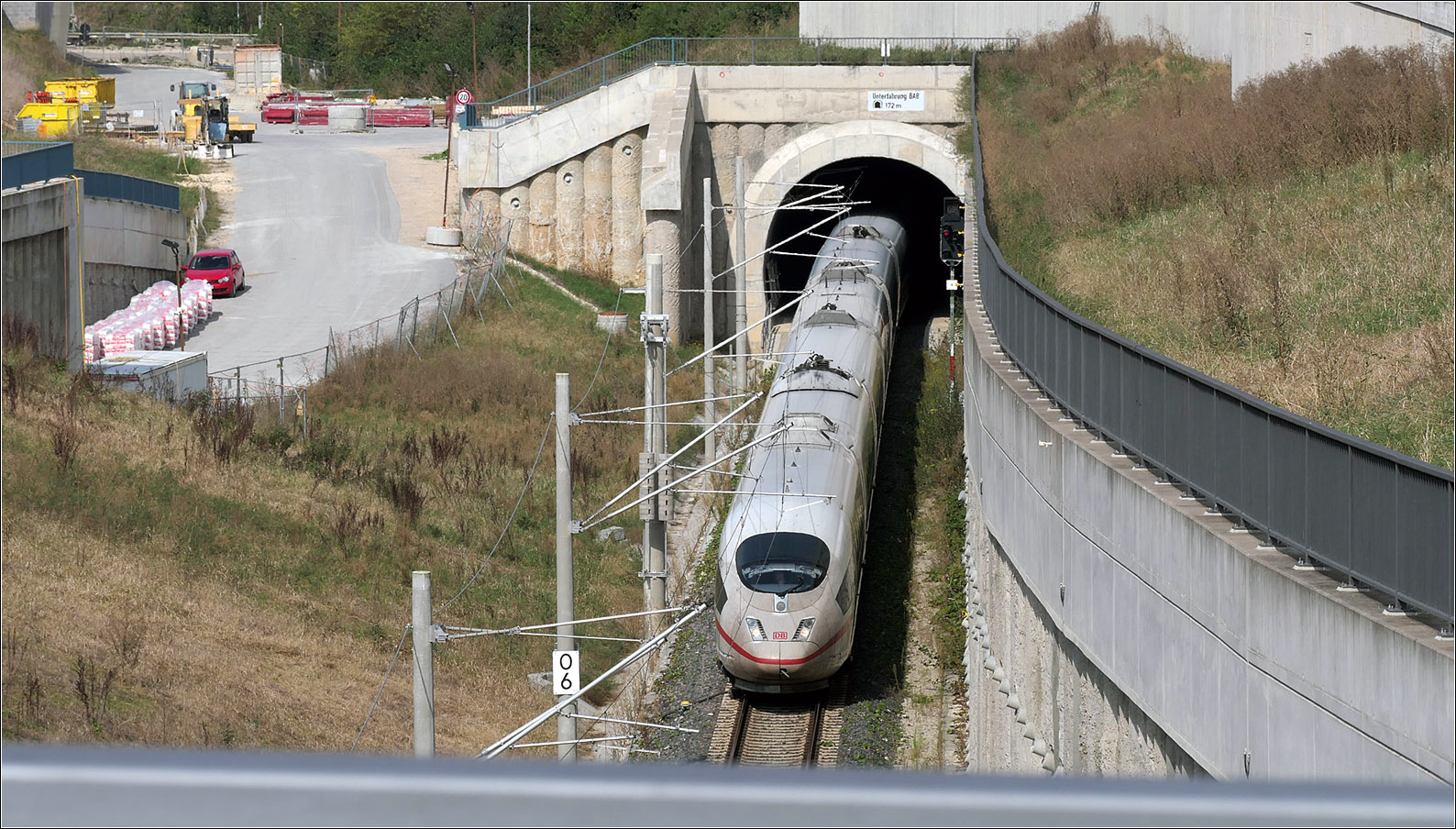 Im tiefen Graben -

... wechselt ein ICE 3 von Neckartalbahn über die Güterzuganbindung auf die Schnellfahrstrecke in Richtung Ulm. Der kurze Tunnel im Hintergrund ist 172 m lang und wurde bergmännisch unter der Autobahn A8 hindurch gegraben.

Links im Bild wo neben dem roten Auto Material gelagert ist, wird später mal das Gleis der 'Großen Wendlinger Kurve' liegen, das hier aus einer Tunnelröhre kommt um dann in die Schnellfahrstrecke Richtung Stuttgart einzufädeln. 

24.09.2024 (M)