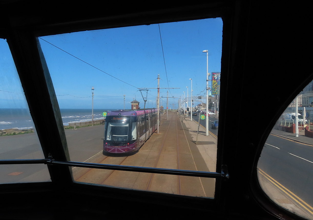 In Blackpool verkehren im Normalverkehr moderne Flexity-Trams: Blick aus der oberen Etage des doppelstöckigen Trams der Heritage-Linie auf Strassenbahn und Meer. Blackpool, 12.5.2022