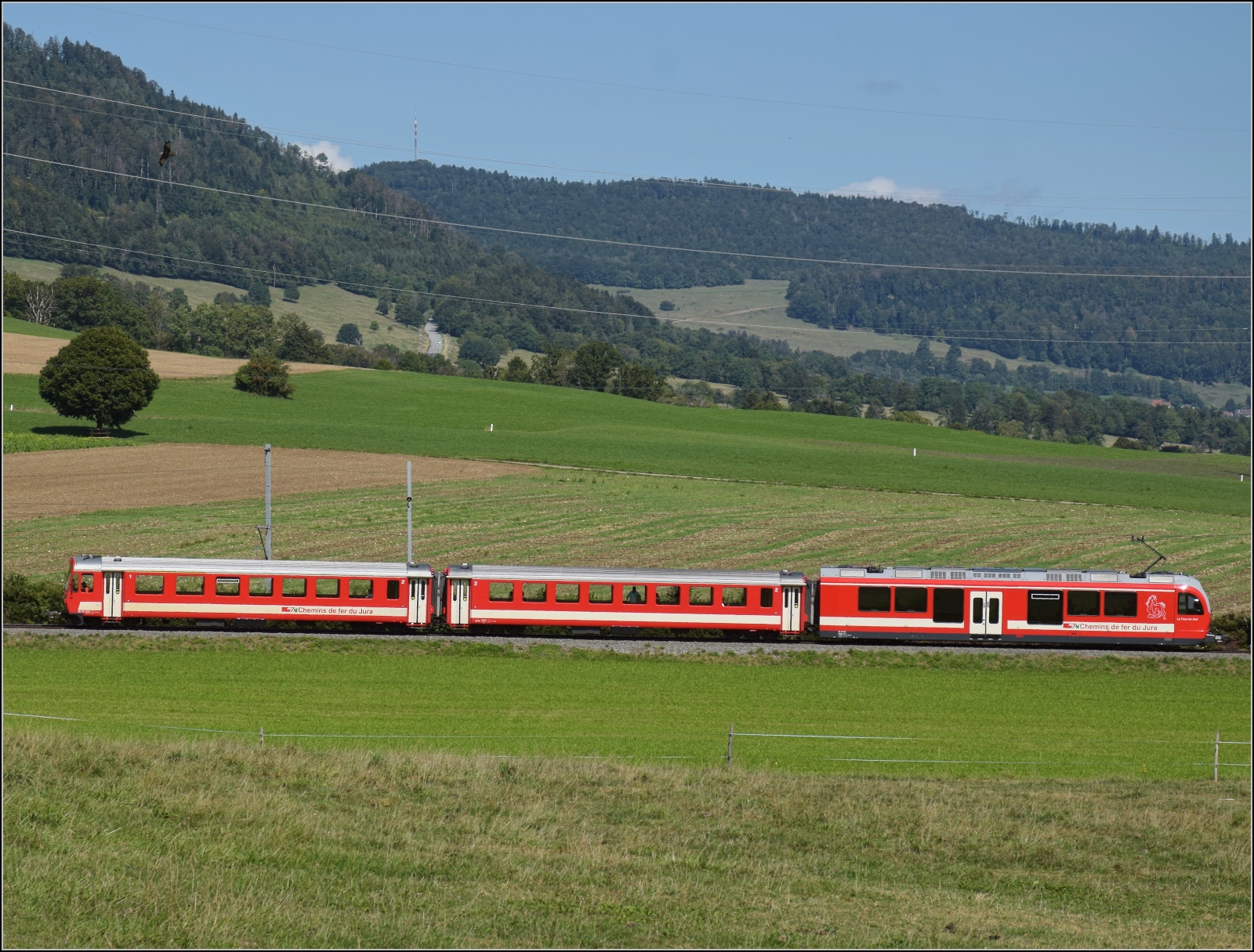 In weitem Bogen umfährt die Strecke auf die Freiberge den Ortskern von Glovelier. Be 4/4 'Le Paon de Jour' schiebt die beiden Personenwagen älteren Datums die Steigung hinauf. September 2022.

Sollte irgendetwas mit dem neuen Bildformat nicht passen, bitte an mich per PN, werde ich gesammelt weiterleiten. Auch wenn alles klappt oder die großen Bilder Anklang finden, bitte eine kurze Rückmeldung... Inzwischen kann jeder bei Bedarf das neue Format selber nutzen.