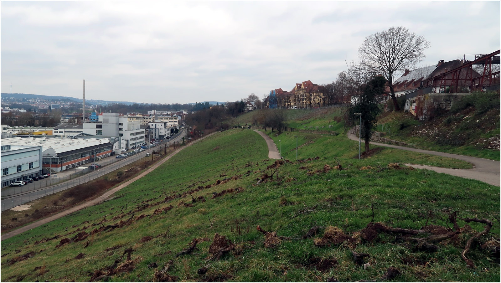 Industriebahn Stuttgart-Münster - Bad Cannstatt - 

Blick auf den Weinberg durch den die Industriebahn mit einem Gefälle von etwa 30 Promille ins Neckartal hinunter führte. Die Trasse führte rechts auf dem oberen Weg und dann weiter entlang der Stützmauer den Hang hinab. Unten rechts neben der Straße befand sich die Gleistrasse zum Kraftwerk Münster. Vom Bahnhof Münster kommend mussten die Züge spitz kehren um zum Kraftwerk Münster fahren zu können. Links der Bildmitte wo in etwa die Trassen zusammentreffen steht noch eine Wagenhalle. 

28.02.2023 (M)