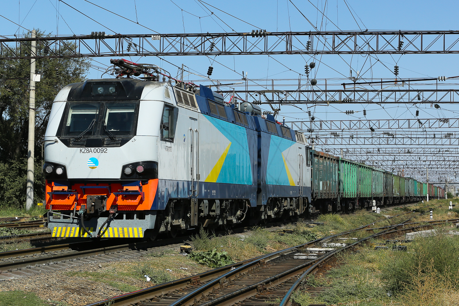 KZ8A 0092 mit Schüttgut Wagen im Bahnhof von Taraz in Kasachstan. Dort haben die Leute noch niemals jemand gesehen der Trainsoptting als Hobby hat. Die Menschen waren überaus interessiert was ich da mache und sehr freundlich zu mir. Am letzten Tag gäbe es dann noch ein Gespräch mit der Polizei und dem Chef des Bahnhofs was aber auch gut ausging. Ich möchte hiermit allen Menschen von Taraz herzlich danken, welche am Ende verständnisvoll unser Hobby akzeptieren. 