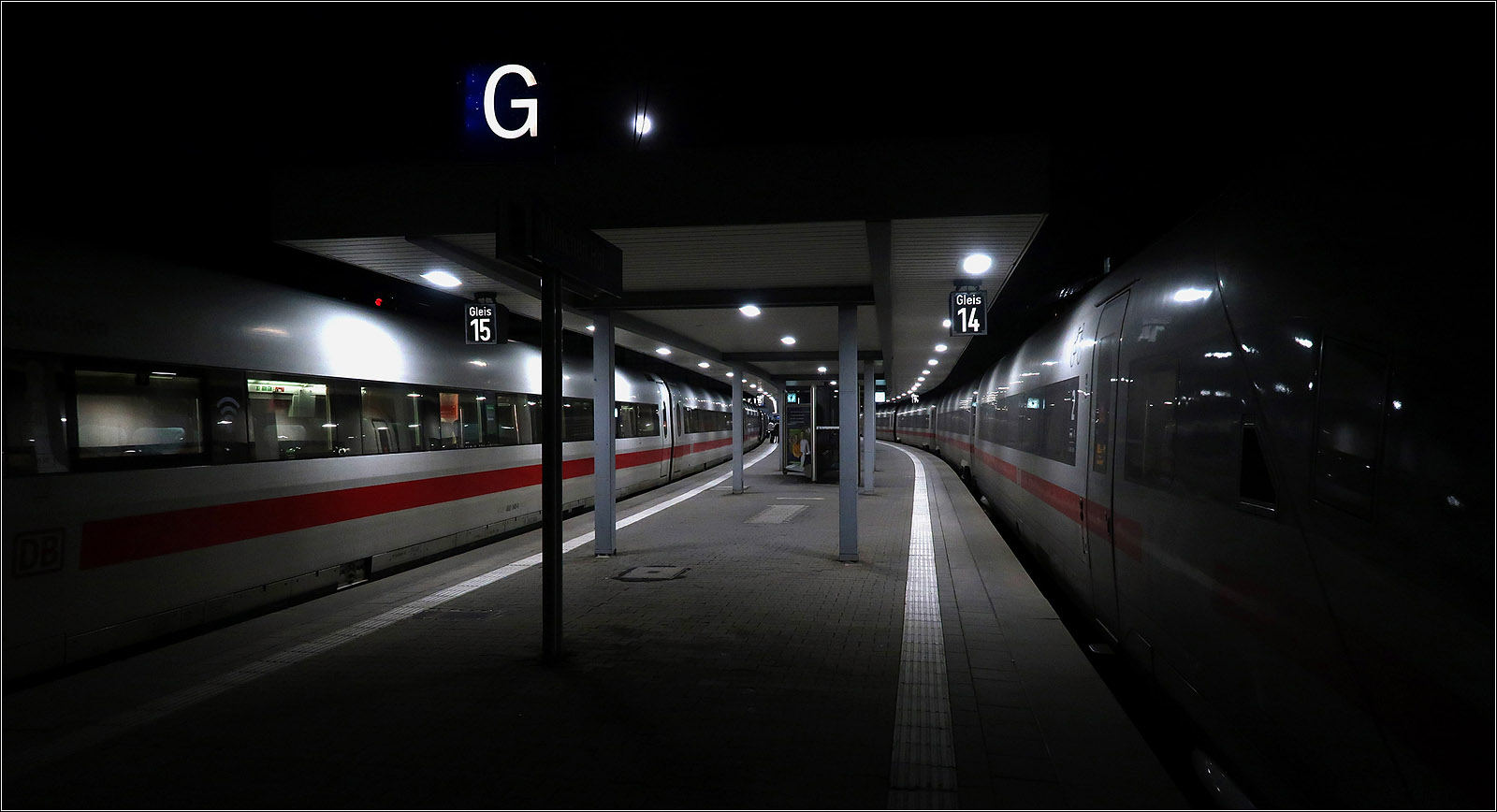 Licht unter dem Bahnsteigdach -

Während die beiden ICE-Züge im Bereich des Bahnsteigdaches von der Beleuchtung angestrahlt werden, verschwinden die Züge außerhalb des Daches in der Dunkelheit der Nacht.
München Hauptbahnhof an den Gleisen 14 und 15, links ein ICE 1, rechts ein ICE 4.

07.11.2022 (M) 

