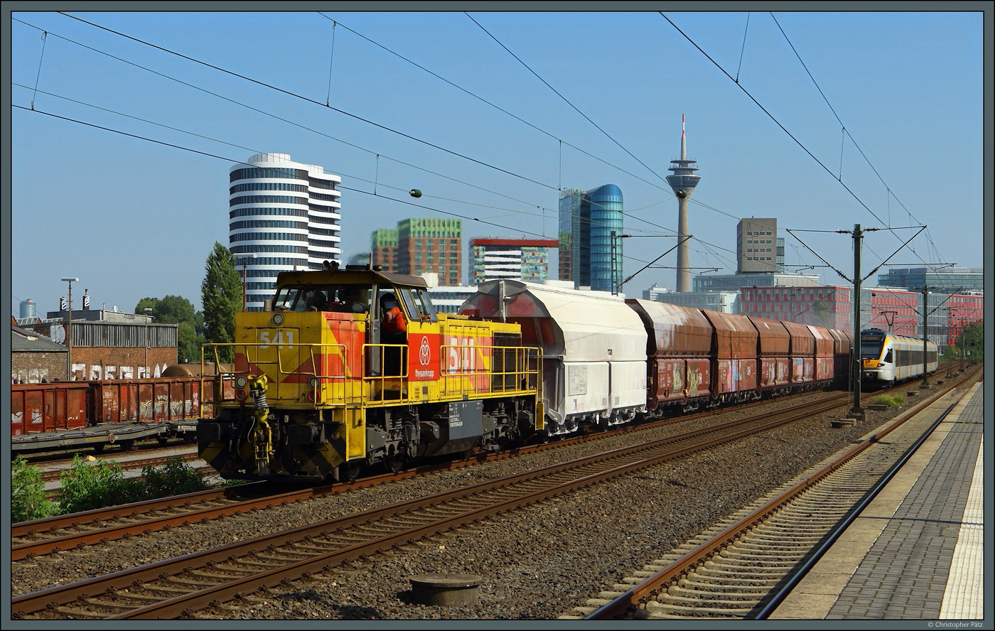 Lok 541 der ThyssenKrupp zieht am 10.09.2023 ihren Kalkzug am Haltepunkt Düsseldorf-Hamm vorbei und begegnete dabei einem Flirt der Eurobahn. Im Hintergrund ist mit dem Rheinturm auch das Wahrzeichen von Düsseldorf zu sehen.
