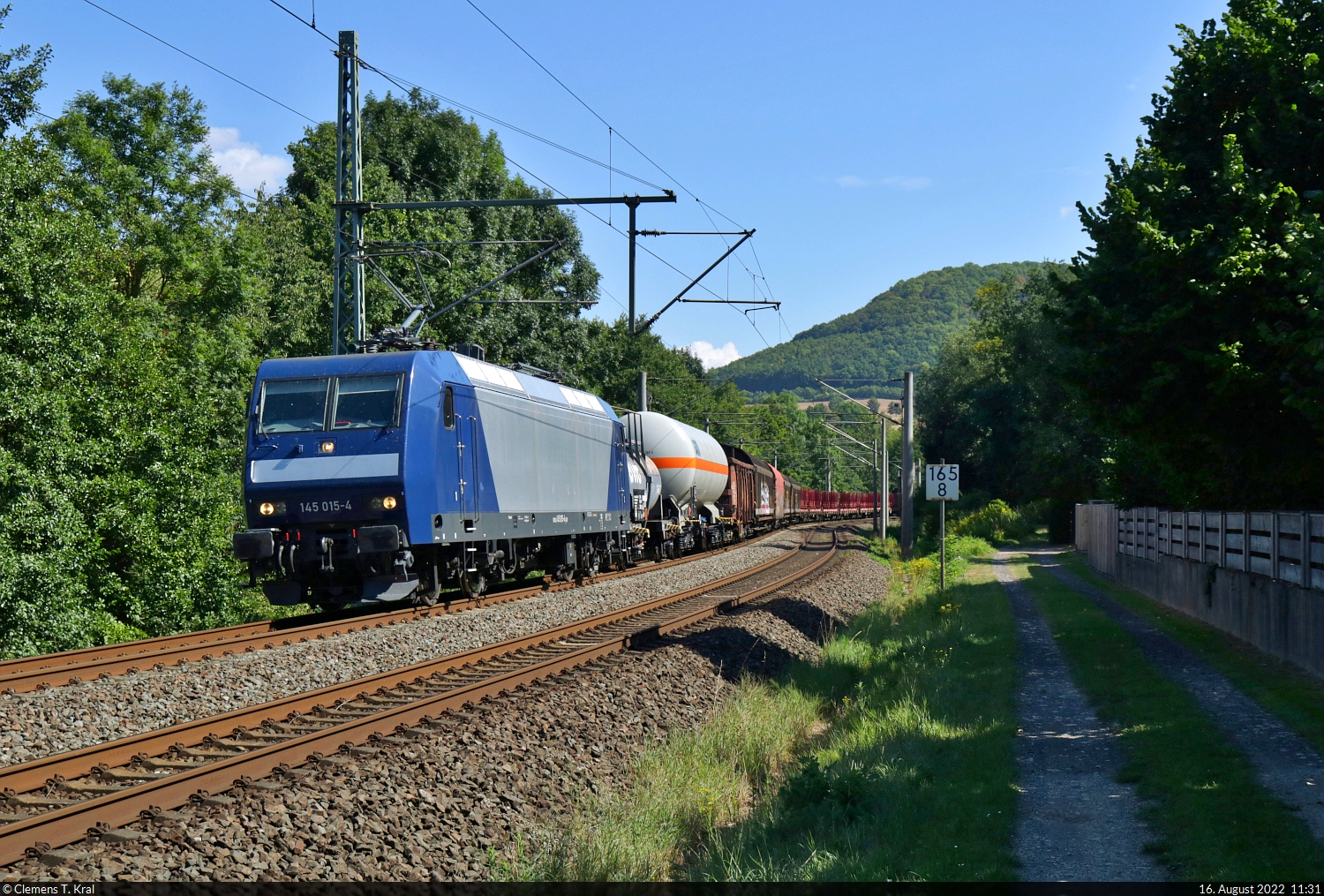 Mit dem Fahrrad von Kassel nach Halle (Saale) | Tag 2 Witzenhausen–Gernrode-Niederorschel
Strecken-km: 165,8

Nach der Fulda und der Werra folgen wir für die nächsten Kilometer dem Flüsschen Leine. An einem kurzen Teilstück östlich von Arenshausen, das direkt neben der Strecke verläuft, leuchtete das Signal Richtung Eichenberg grün. Eine willkommene Einladung zum Stehenbleiben also. Zum Vorschein kam 145 015-4 mit einer Schlange verschiedener Güterwagen.

🧰 DB Cargo, vermietet an die RBH Logistics GmbH
🕓 16.8.2022 | 11:31 Uhr