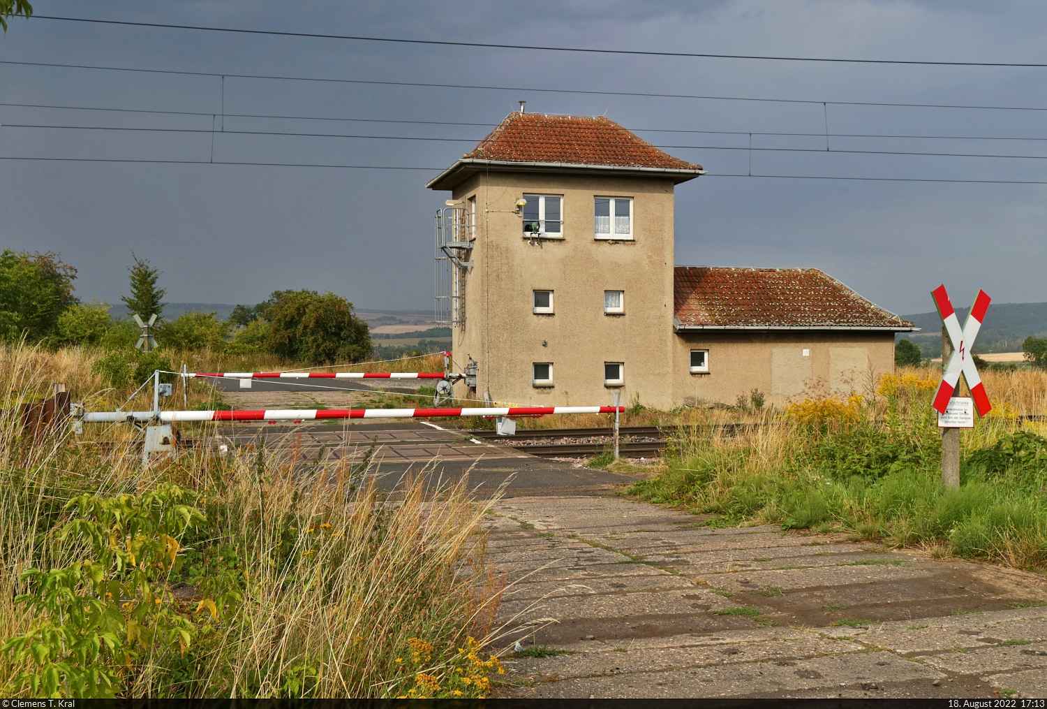Mit dem Fahrrad von Kassel nach Halle (Saale) | Tag 4 Berga-Kelbra–Riestedt
Strecken-km: 54,9

Von Sangerhausen nach Riestedt steigen sowohl Bahn- als auch Radstrecke deutlich an. Eine letzte Pause wird nötig – und zwar an der Blockstelle Steinberg, mitten in der Landschaft. Das mechanische Stellwerk mit Wechselstromblock ( Einheit Mw ) und Relais-Technik der Bauart  GS II DR  bedient auch eine Anrufschranke. Personen, die den Weg passieren wollen, müssen sich durch klingeln, rufen oder hupen erkenntlich zeigen. Das können sie allerdings lange versuchen, denn wie ich später von Anwohnern erfuhr, ist das Häuschen wegen Personalmangels schon seit Monaten unbesetzt. Die Blockstelle ist damit durchgeschaltet, was die Streckenkapazität zusätzlich einengt.
Auf die andere Seite gelangt man aber trotzdem durch eine Unterführung, die etwa 600 Meter weiter östlich liegt.

🕓 18.8.2022 | 17:13 Uhr