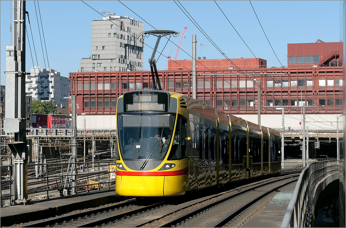Nach der Durchfahrt unter dem Postgebäude - 

... hat hier ein Stadler Tina-Tram die Viaduktstrecke neben den SBB-Gleisen erreicht und wird gleich in die Haltestelle Peter Merian einfahren.

Basel, 18.09.2025 (M)