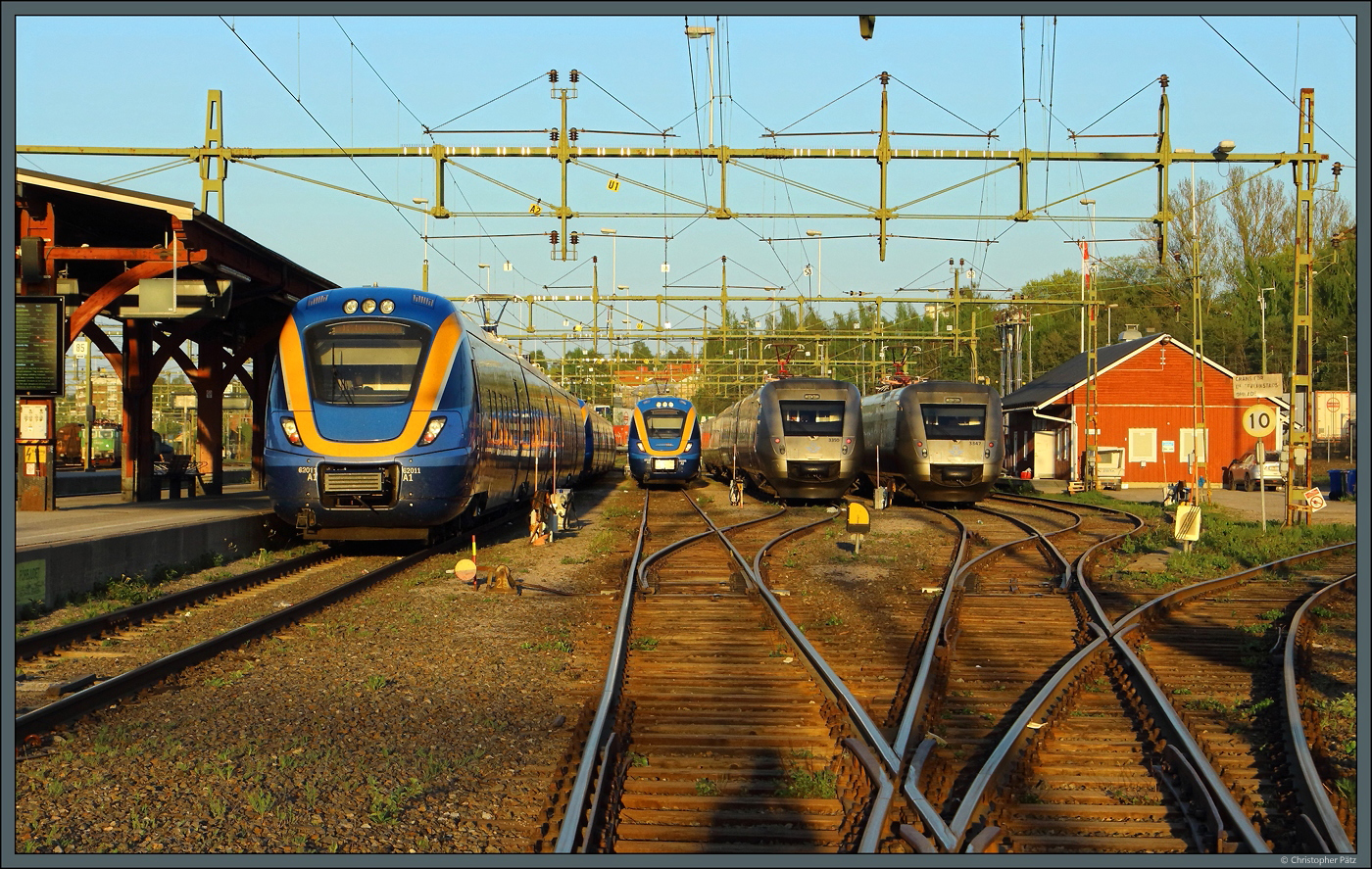 Nach getaner Arbeit stehen am Abend des 20.05.2023 mehrere Triebwagen der Baureihen X62 und X55 in Sundsvall. Von links nach rechts sind die Coradia Nordic 62011 und 62008 der Norrtåg sowie 3350 und 3347 der SJ zu sehen. Das Bild entstand von einem geöffneten Bahnübergang.