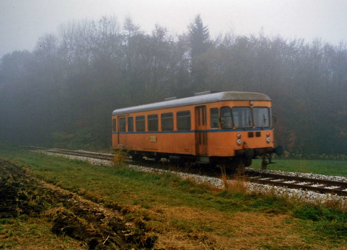 Nebenbahn im Nebel: Fuchs-Triebwagen T 05 von 1956 (Fabriknummer 9055) auf der WEG-Nebenbahn Amstetten-Gerstetten bei langsamer Fahrt zwischen Schalkstetten und Stubersheim noch mit seiner alten Farbgebung. Der Wagen stammte aus der letzten Lieferung der Waggonfabrik Fuchs an die W�rttembergische Eisenbahngesellschaft. Danach mussten alternative Hersteller weitere Bestellungen der WEG und auch der W�rttembergischen Nebenbahnen AG �bernehmen. T 05 wurde sp�ter verschrottet.
Datum: 02.11.1984