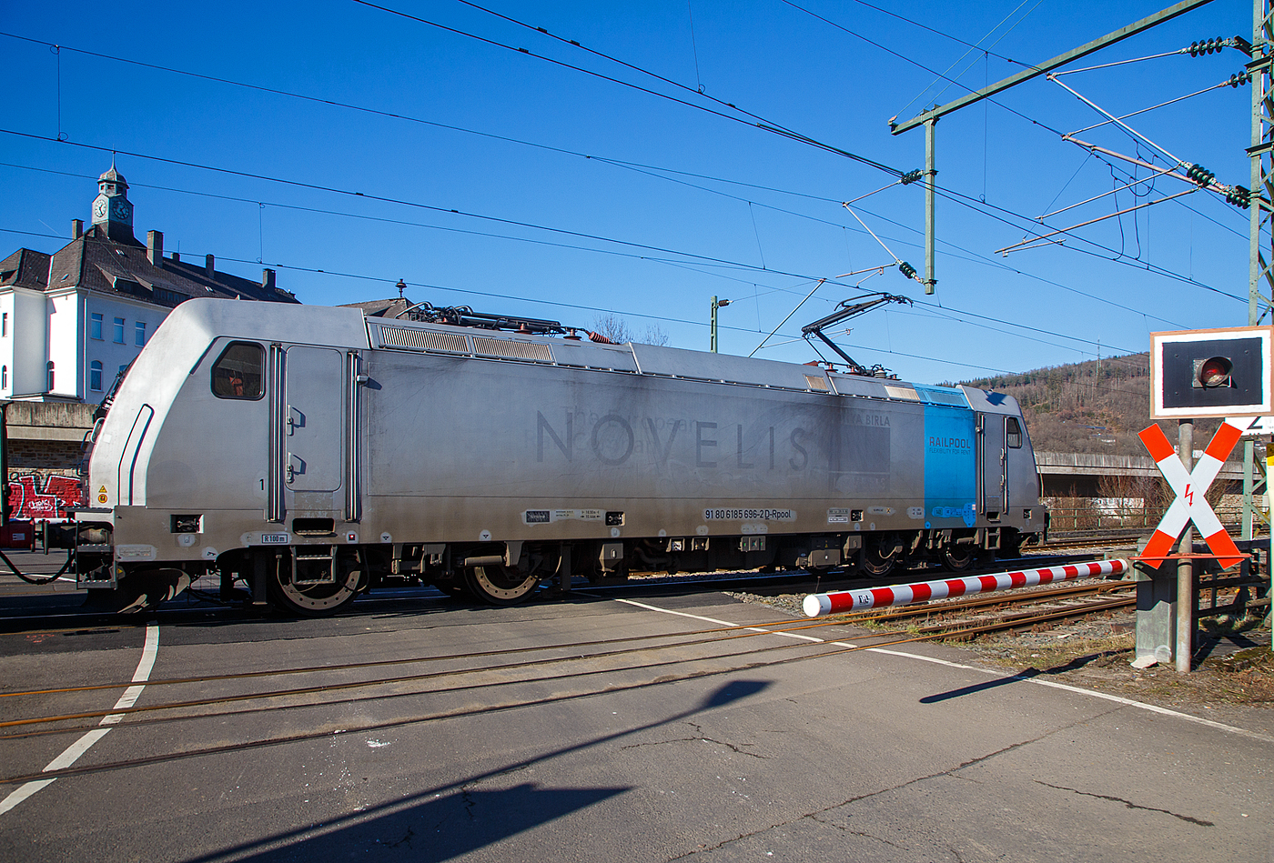 Nun sind die Schranken am Bü 343 geschlossen und sie hat Hp 1 oder 2...
Die 185 696-2 „Marie-Chanthou“ (91 80 6185 696-2 D-Rpool) der Railpool fährt am 14.02.2023 mit einem Druckgas-Kesselwagenzug über die Siegstrecke (KBS 460), durch Niederschelderhütte in Richtung Siegen.

Die TRAXX F140 AC2 wurde 2010 von Bombardier in Kassel unter der Fabriknummer 34722 gebaut und an die Railpool geliefert. Die Lok ist für Deutschland und Österreich zugelassen. Die ehemaligen Zulassungen für Schweden und Norwegen sind nun durchgestrichen.