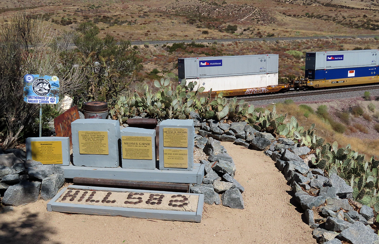 Nun ist unsere gewünschte Fotostelle erreicht. Der Hill 582 heisst so, weil er offenbar 58.2 Meilen von Barstow entfernt ist. Bei unserer Ankunft waren dort drei ältere Herren an der Arbeit. Sie erzählten uns, dass vor etwa 30 Jahren sechs Männer sich zum Ziel gesetzt hätten, diese Fotostelle auf diesem Hügel nahe an den Gleisen zu errichten und unterhalten. Im Bild ist der Containerzug auf der mittleren Spur zu sehen (BNSF), das Gleis im Hintergrund gehört der UP. Cajon Pass, CA, 21.9.2022