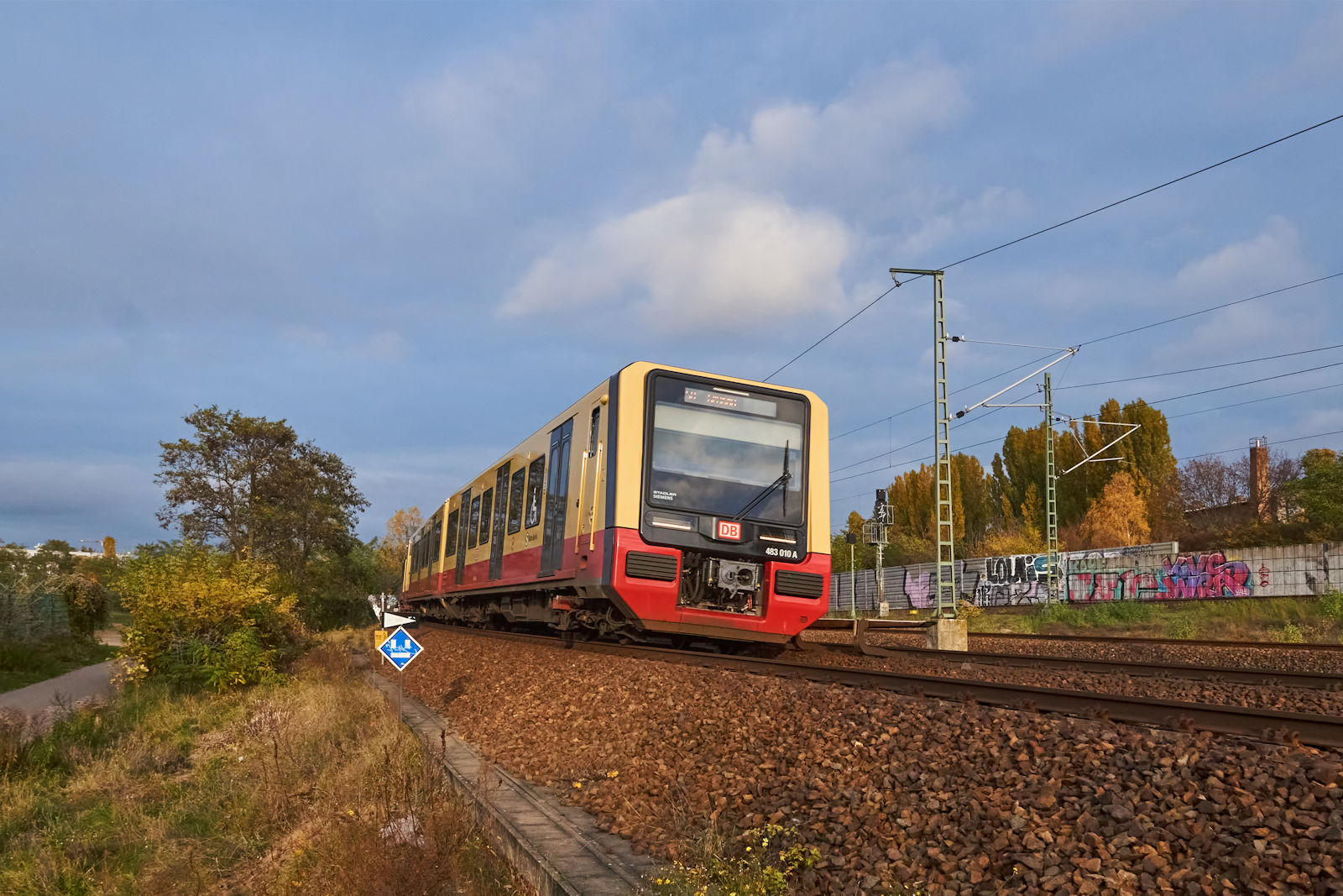 Nur wenige Minuten ließ sich die Sonne am 11.11.2023 über Berlin blicken. Zu diesen Momenten gehörte auch jener, als 483 010 auf der S8 nach Grünau Pankow in Richtung Süden verlassen hat. In Kürze trifft der Zug auf die Nordbahn und wird sich in den Bahnhof Bornholmer Straße einfädeln.