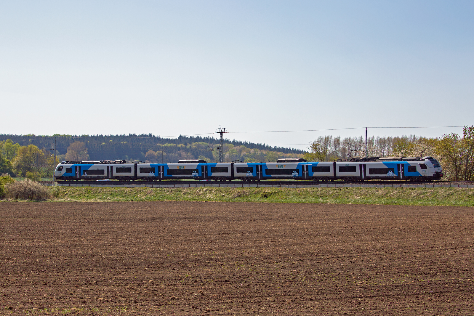ODEG Triebwagen als RE 9 bei Mukran auf einem Streckenabschnitt mit neu bestelltem Feld im Vordergrund. - 12.05.2023