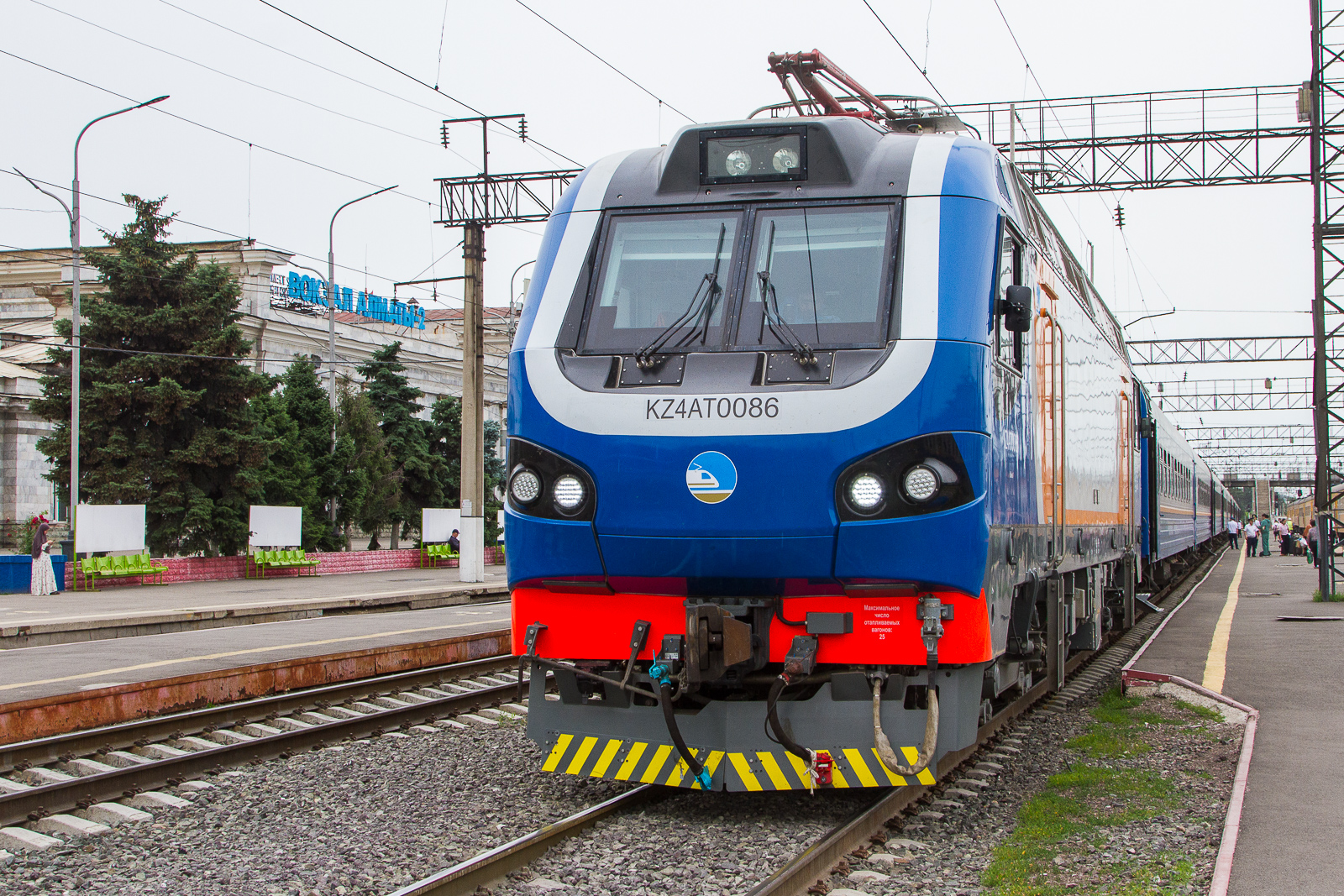Prima M4 KZ4AT ist die Typenbezeichnung der Lokomotive mit der Nr. 0086  aus dem Baujahr 2026 der nationalen Eisenbahngesellschaft Qazaqstan Temir Joly (QTJ). Hersteller ist der franz�sische Konzern Alstom. Die neuen Loks wurden meiner Information nach in Kasachstan fertig montiert. Bei meinem Aufenthalt am Bahnhof Almaty 2 am 5 Juni 2026 habe ich gleich mehrere dieser Exemplare gesehen. Altes Eisen ist dort wohl Geschichte. Auch die Strassenbahn dort wurde 2015 schon abgeschafft.  