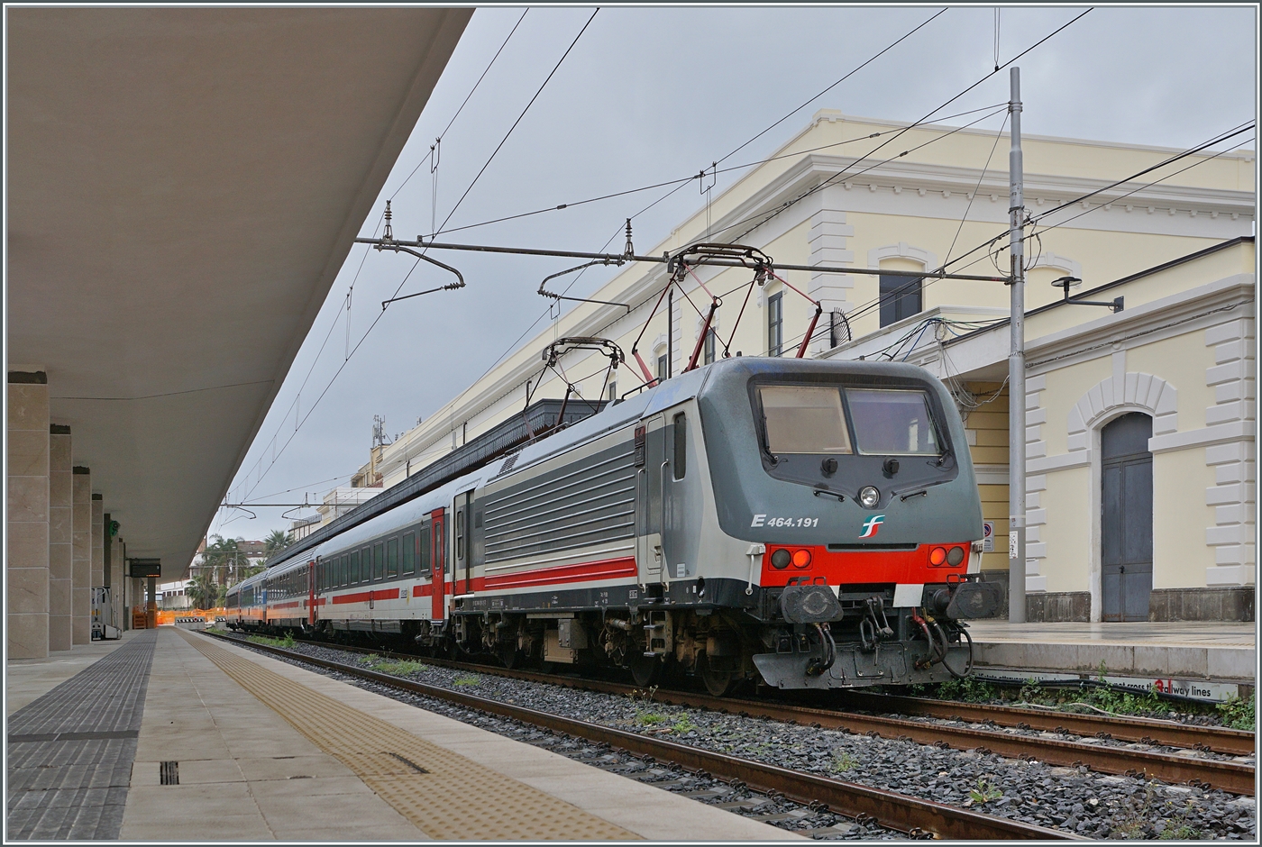Pünktlich wie die Eisenbahn... Oder schon fast überpünktlich: Die Reise von Siracusa nach Villa San Giovanni hatten wir bereits im Herbst gebucht, bekam dann einige Wochen vor Abfahrt die Benachrichtigung, dass unser iC 724 Siracusa bereits um 10:22 statt um 10:27 verliess, was dann auch zutraf. Auf der Fahrt in Richtung Messina  sammelte  der Zug infolge schlechten Wetters dann bis zu 30 Minuten Verspätung auf, erreichte aber vereint mit dem Zugteil von Palermo nach der Fährüberfahrt Villa San Giovanni gut 15 Minuten vorzeitig um 14:20 statt 14:35, und wir den Anschlusszug nach Reggio di Calabria um 14:32...

Die FS Trenitalia E 464.191 stellt in Siracusa den iC 724 nach Roma Termini bereit. 

16. März 2026  