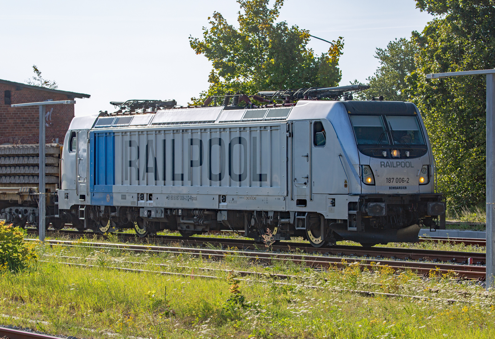 RAILPOOL Lok 187 006 wartet mit einem Schwellenzug in Bergen auf Rügen auf die Ausfahrt in Richtung Lietzow. - 15.09.2023 
