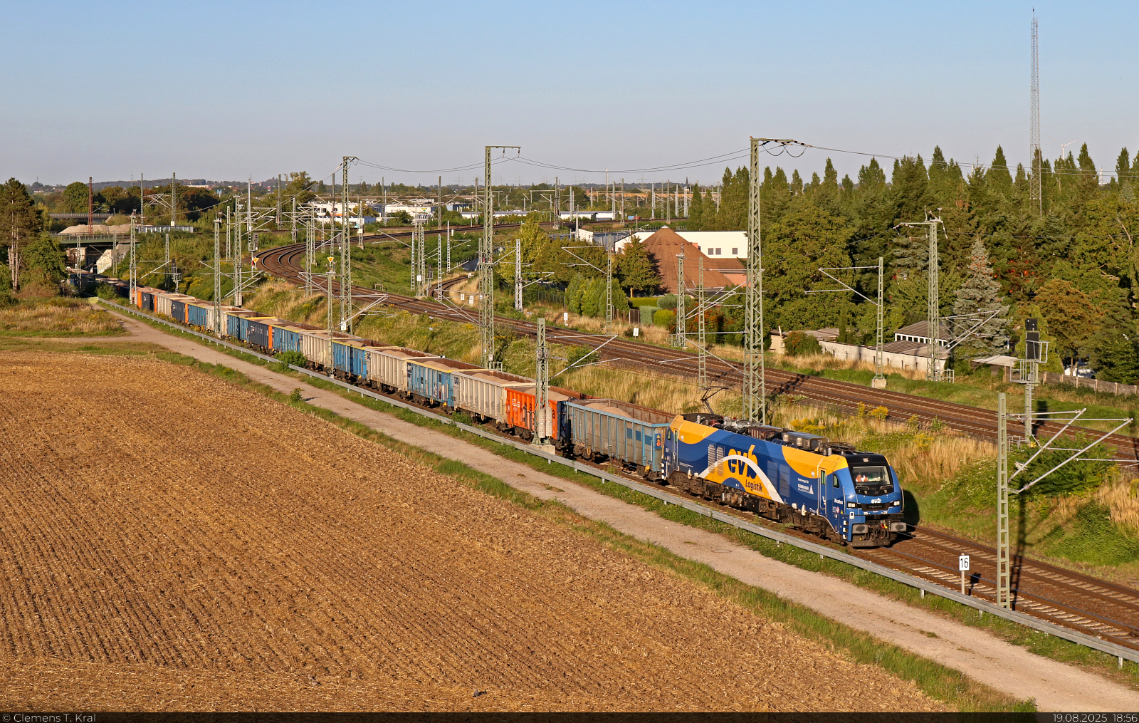 Sandige Fuhre: 2159 229-4 (Stadler Eurodual) unterwegs mit Hochbordwagen, die mit Sand vermutlich aus Sachsendorf (Barby) beladen sind, am Birkhahnweg in Halle (Saale) in s�dlicher Richtung.

🧰 European Loc Pool AG (ELP), vermietet an die Eisenbahnen und Verkehrsbetriebe Elbe-Weser GmbH (EVB), untervermietet an die BELog Baustoffe- Entsorgung- Logistik GmbH & Co. KG
🕓 19.8.2025 | 18:56 Uhr