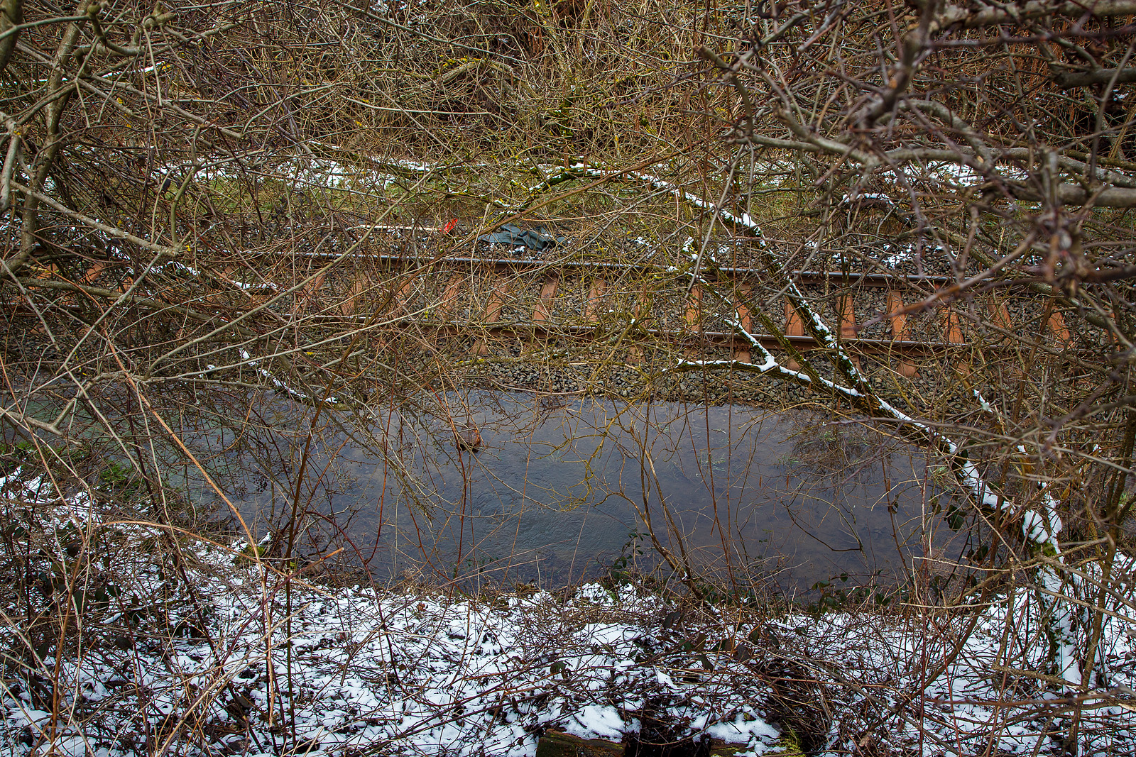 Schlimmer geht immer.....
Totalsperrung der Hellertalbahn (KBS 462 / Strecke 2651).
Nun ist Herdorf Bahntechnisch zur Insel geworden. 
Es gibt seit dem 10.03.23 eine Gleisunterspülung auf der Strecke 2651 bei km 91,0, so ist vorerst auch kein Güterverkehr von Haiger nach Herdorf möglich. Da die Strecke Betzdorf – Herdorf, bereits wegen dem Felsstutz  am 23.12.2022, seitdem gesperrt ist Herdorf nun Bahntechnisch ganz abgeschnitten. 

Hier unten kommt mächtig viel Wasser einem aus Rohr oder Stollen gequollen, da wohl ein Abflussrohr von einem Sammler zum anderen zu ist, bleibt es hier an der Oberfläche und sucht sich seinen Weg auf die andere Seite vom Gleis.